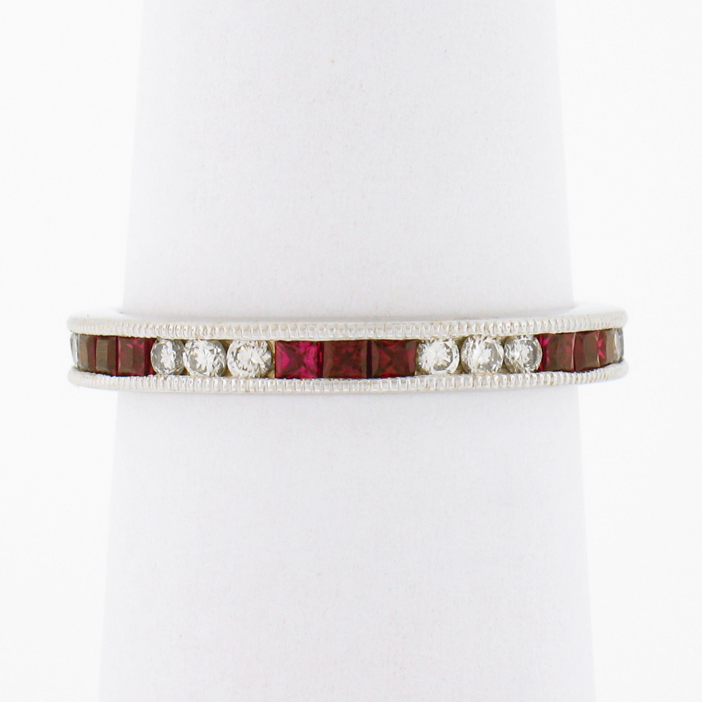 This marvelous ruby and diamond eternity band ring is crafted in solid 18k white gold and features a well made channel setting which is delicately milgrain etched throughout both sides, and securely holds the stunning stones entirely around the