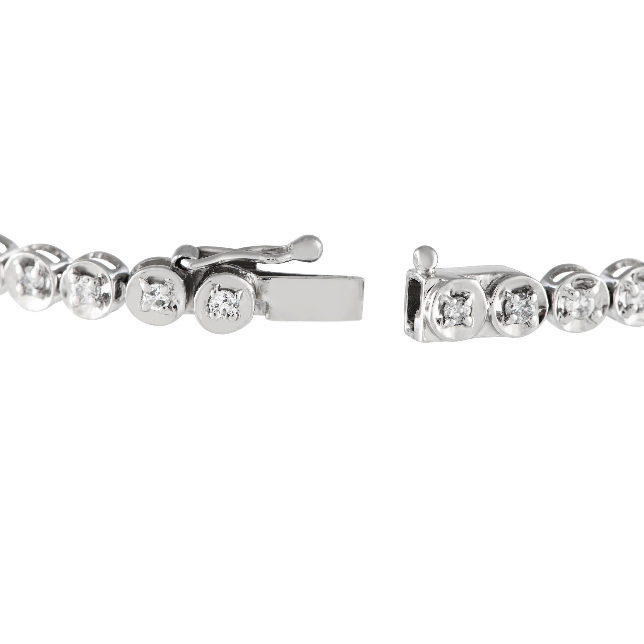 An epitome of minimalistic elegance, this diamond tennis bracelet delivers a non-stop shine that can enhance every attire. The bracelet is designed with a continuous line of petite round diamonds, each mounted on a round four-prong basket. A box tab