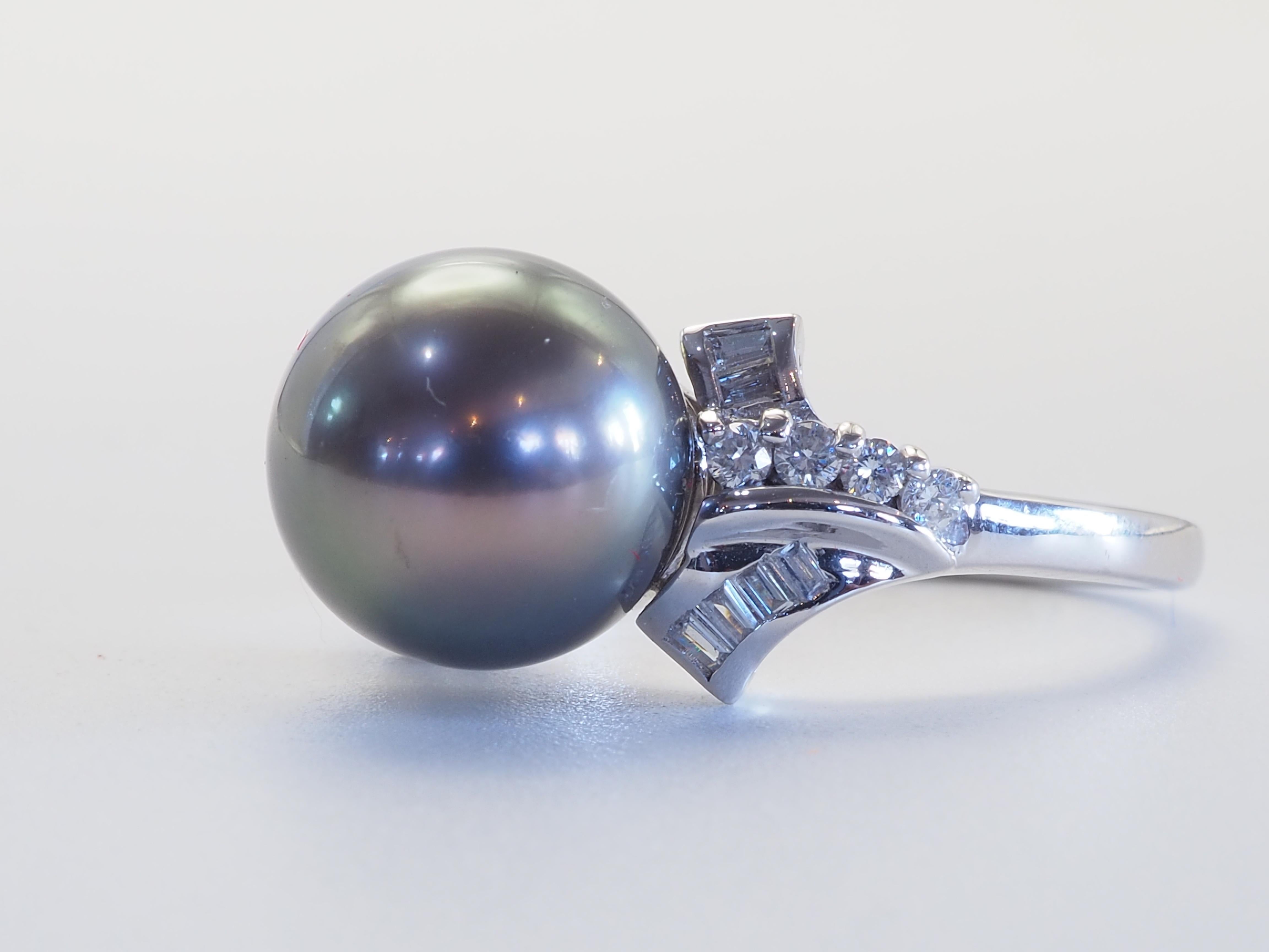 Cette brillante bague en or blanc 18 carats est ornée d'une rare et magnifique perle de Tahiti ! La perle est presque parfaitement arrondie et ne présente que de légères marques d'imperfections naturelles. Le diamètre de la perle est de 10,7 mm. Il