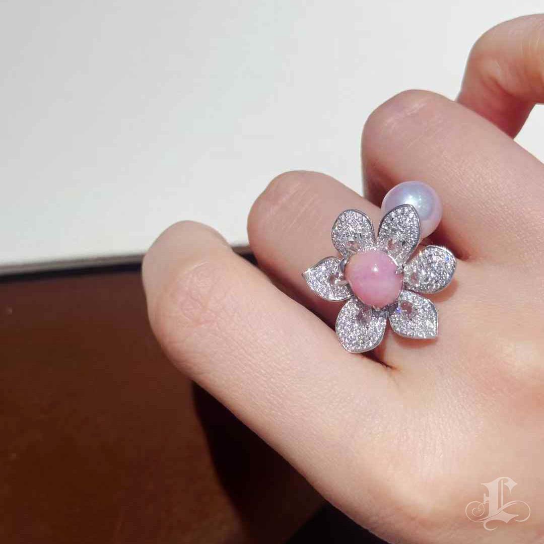 A sculptural tribute to floral elegance, this statement ring showcases a 3.02-carat flamingo pink conch pearl at the heart of a blooming diamond blossom. Accented by 1 carat of natural diamonds and a hidden Akoya pearl nestled in the back, the ring