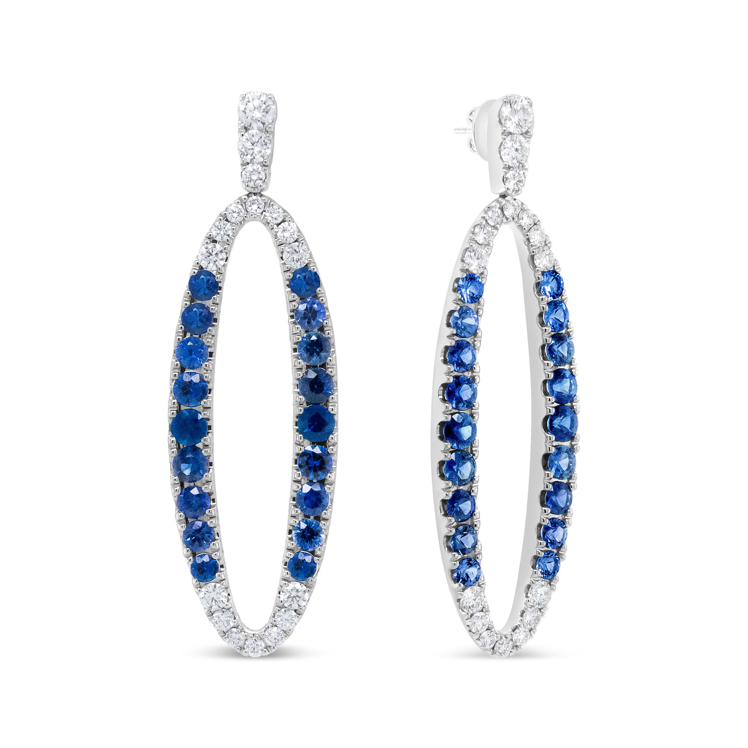 A brilliant sparkle shines supreme from these glorious 18k white gold dangle earrings. An openwork oval hoop silhouette gives this pair a chic, contemporary vibe. Round white diamonds run along the bail and dangle of the earrings, secured in prong