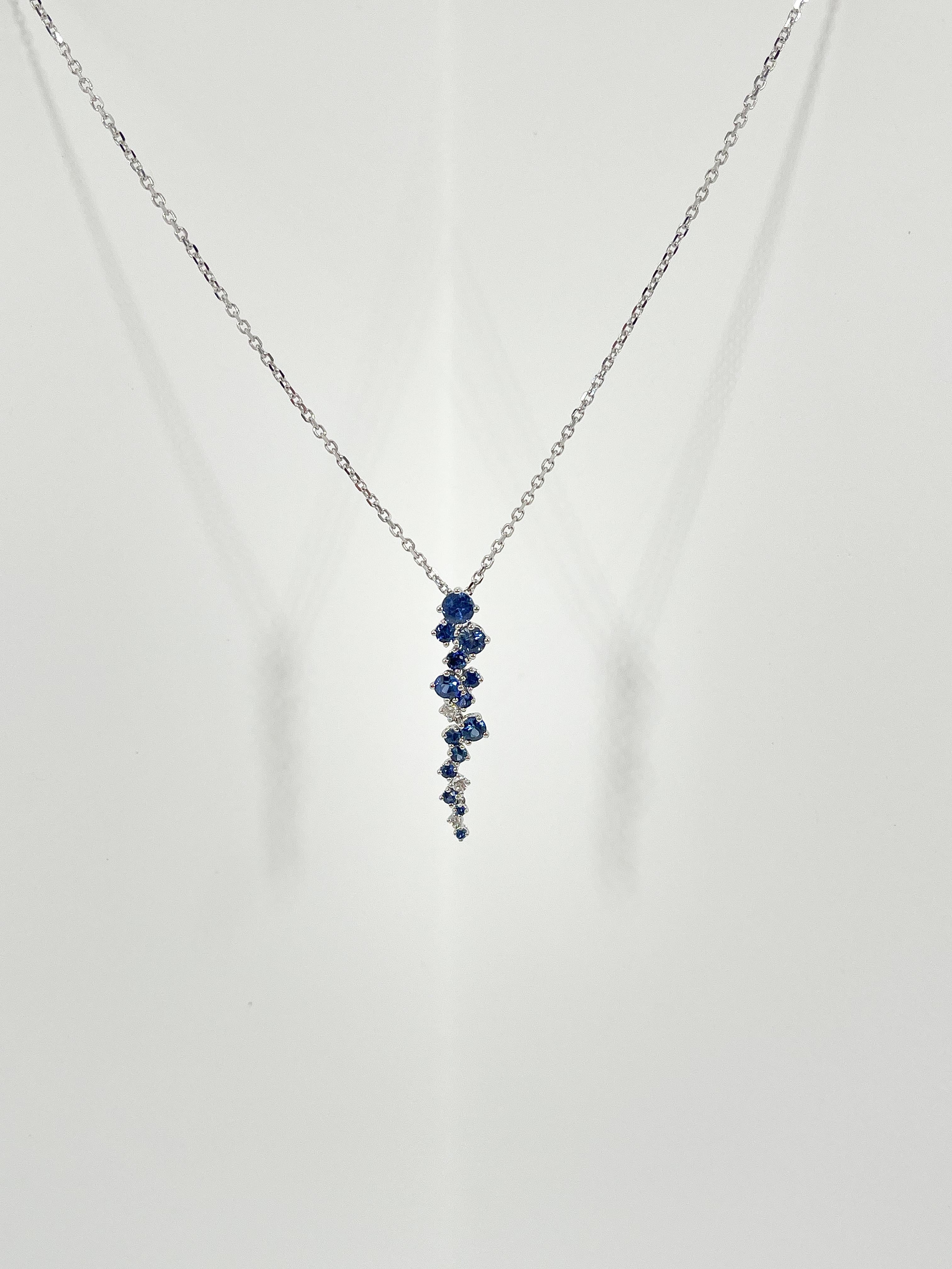 18k white gold 1.11 CTW sapphire and diamond pendant necklace. This necklace has a cluster of 14 sapphires and 3 diamonds of different sizes. The pendant measures 5.1 x 29.4 mm The necklace is 18 inches long and weighs 3.6 grams. 