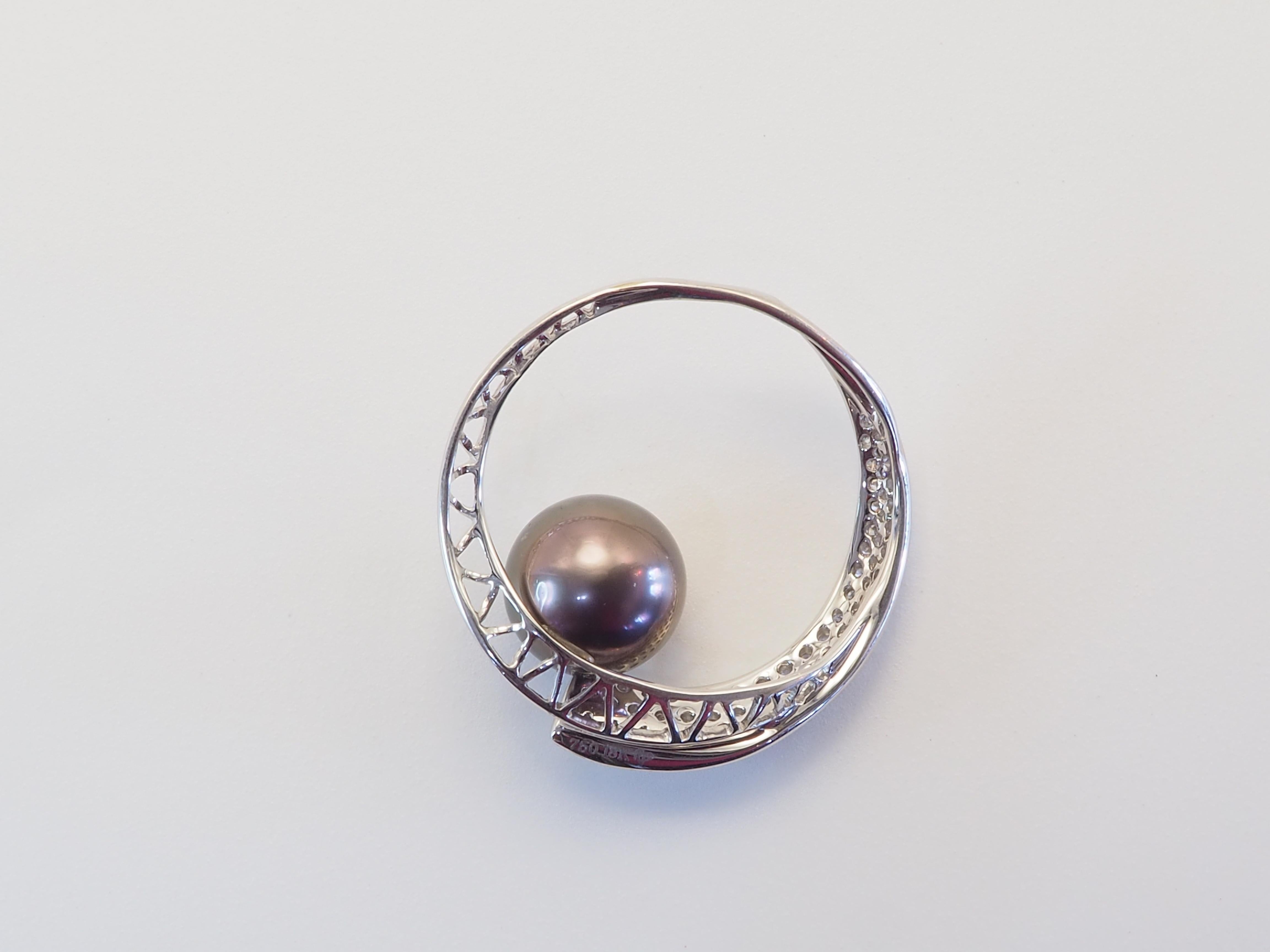 Elegant Geometry Meets Oceanic Grandeur:
This exquisite pendant enhancer showcases a rare, dark-hued South Sea pearl—renowned for its natural luster and generous size—nestled within a sculptural 18K white gold frame. The left arc is adorned with a