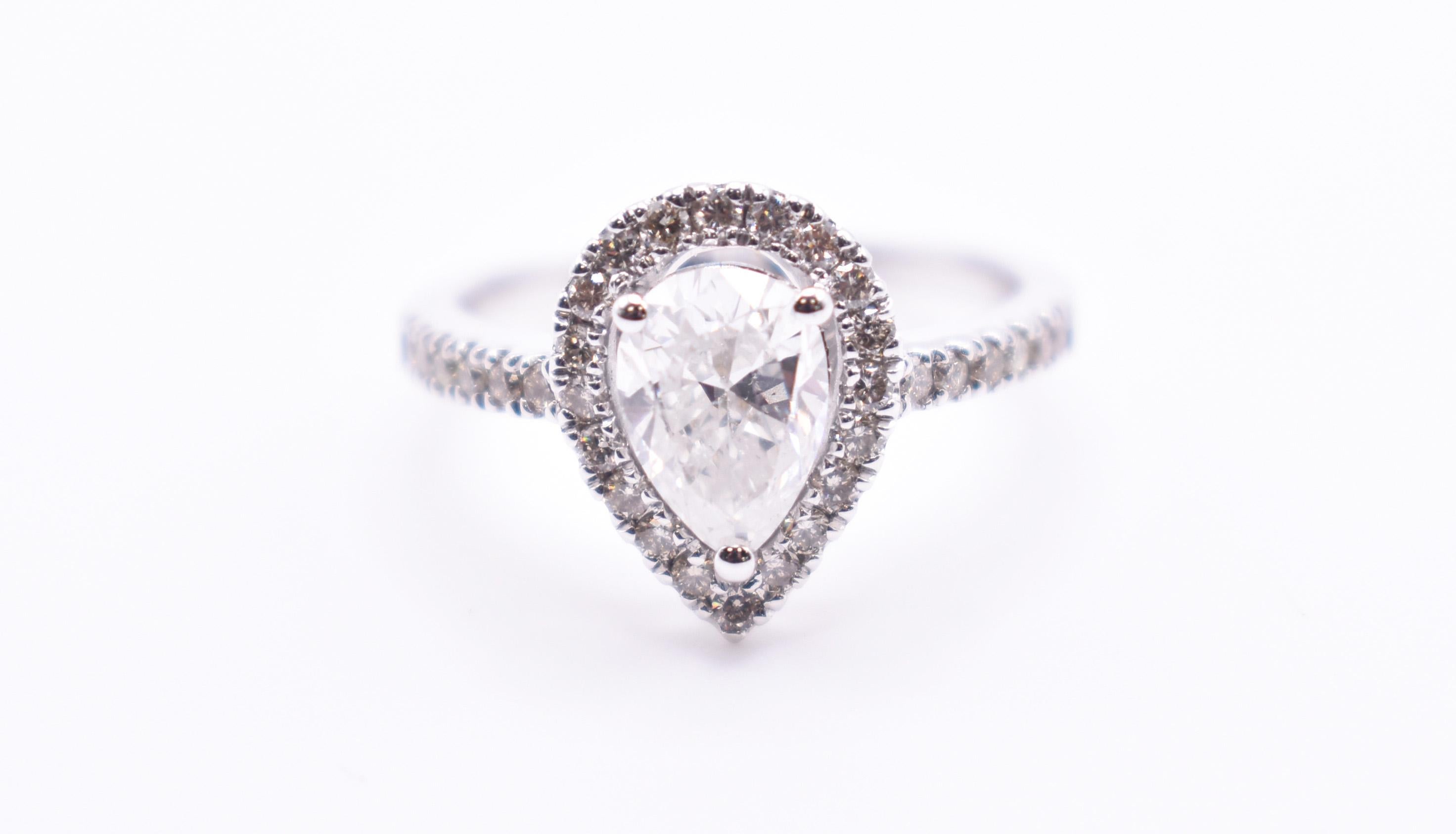 On offer for sale is a superb 18K White Gold 1.18ct pear shaped engagement ring, having a 1.18ct pear shaped diamond to the centre, with a hallo surround and pave sides. 

Metal: 18K White Gold
Total Carat Weight: 1.58ct
Colour: F
Clarity: I2
Size: