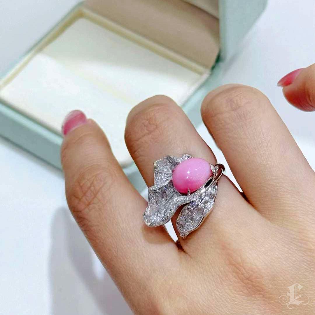 A radiant emblem of organic movement and feminine strength, this Conchéa creation features a 4.42ct natural Flamingo Pink conch pearl nestled within a flowing vine-like structure of diamonds. The pearl’s well-defined flame pattern shimmers