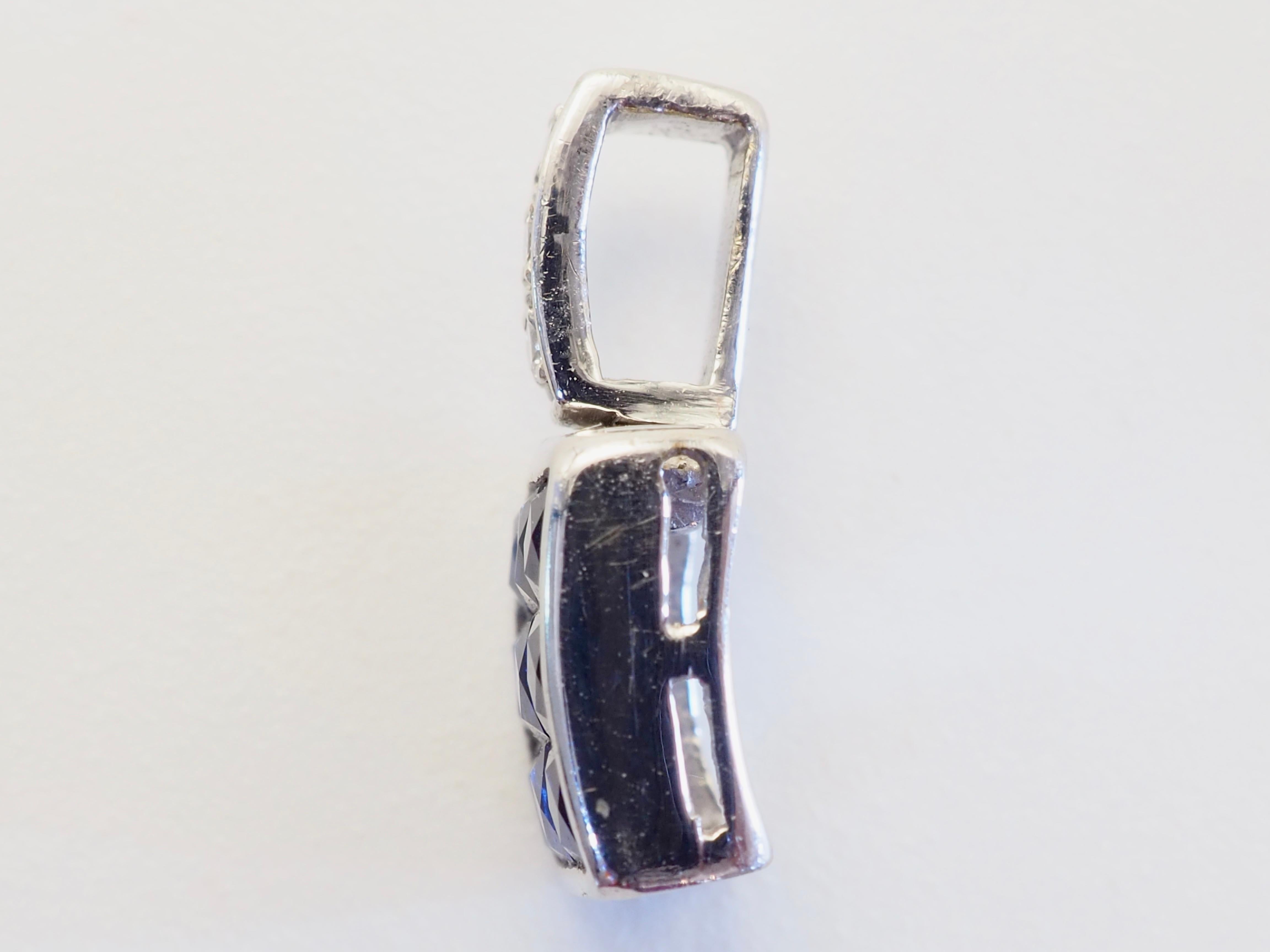 Étude saisissante de symétrie et de saturation, ce pendentif met en valeur neuf saphirs bleus vifs (1,25 carat au total) disposés dans un carré géométrique audacieux. Chaque saphir est taillé avec précision dans un profil pyramidal, créant un jeu