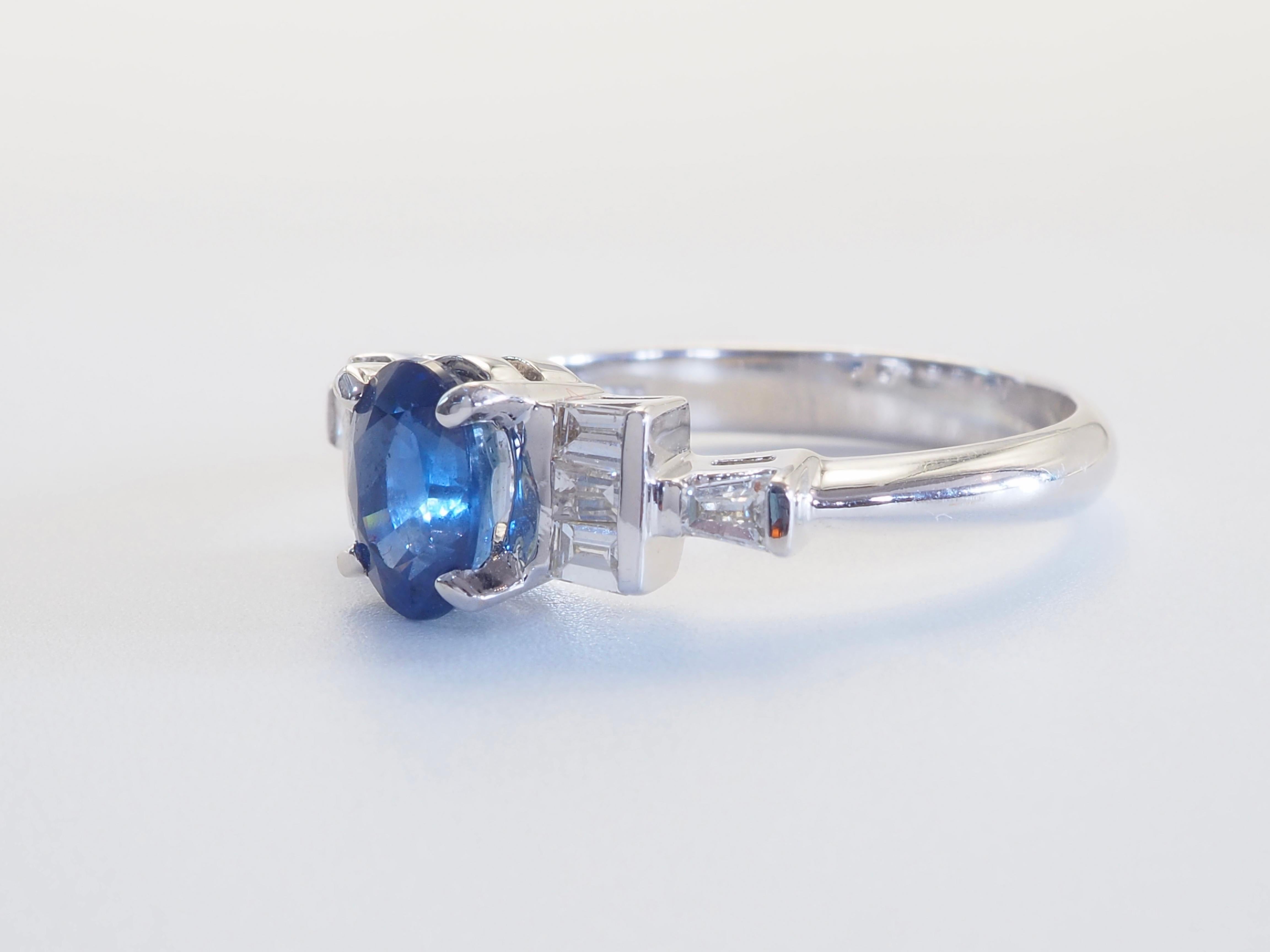 Questo squisito anello presenta uno zaffiro blu dal taglio ovale da 1,30 carati, apprezzato per la sua tonalità ricca e vellutata e per la sua eccezionale limpidezza. Accanto alla pietra centrale ci sono 0,22 carati di diamanti baguette affusolati,