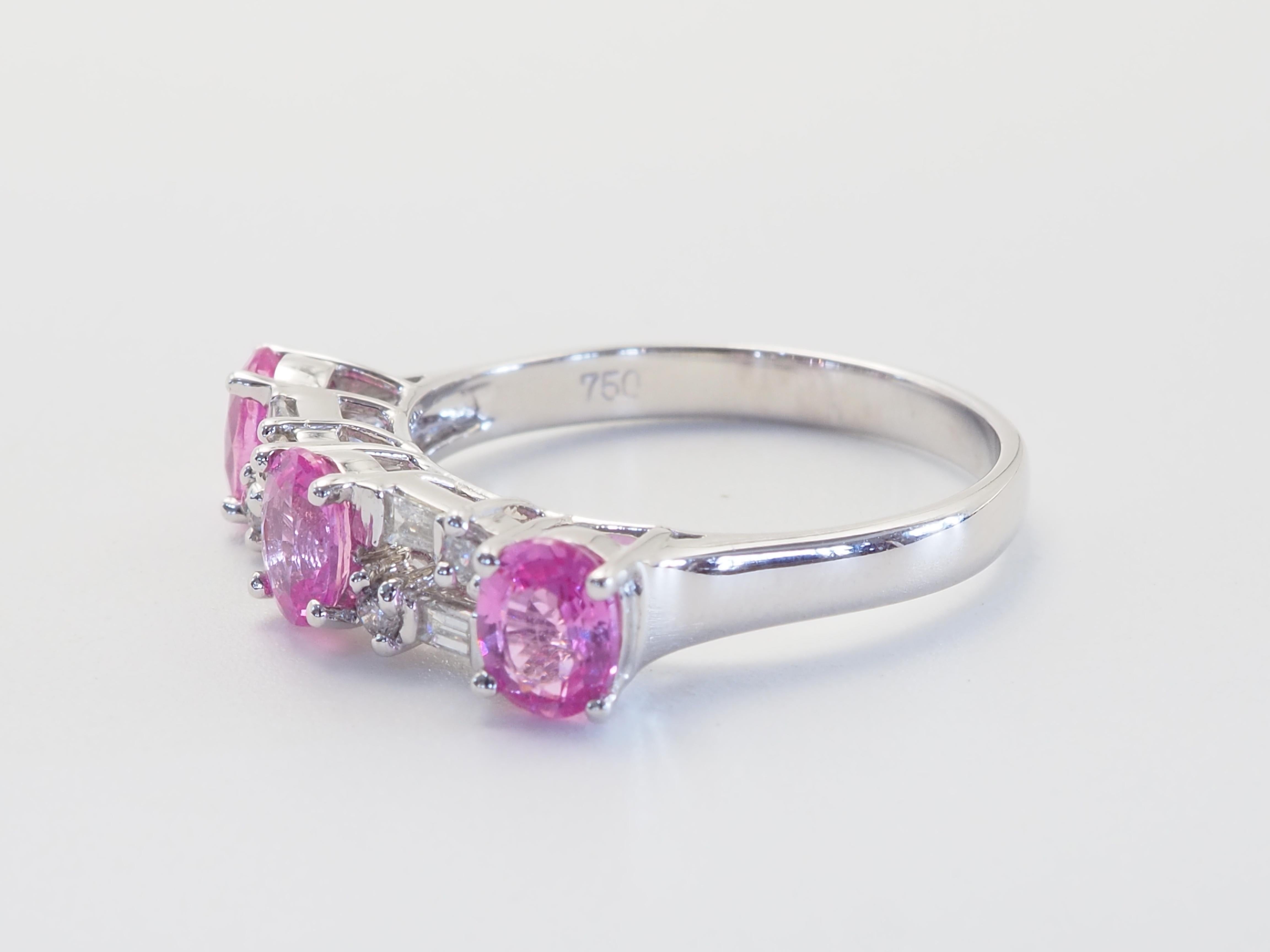 Fusion gracieuse de couleurs douces et d'éclats radieux, cette bague en or blanc 18 carats présente une alternance de saphirs roses et de diamants ronds et baguettes dans un design intemporel. Les pierres roses vives dégagent chaleur et féminité,