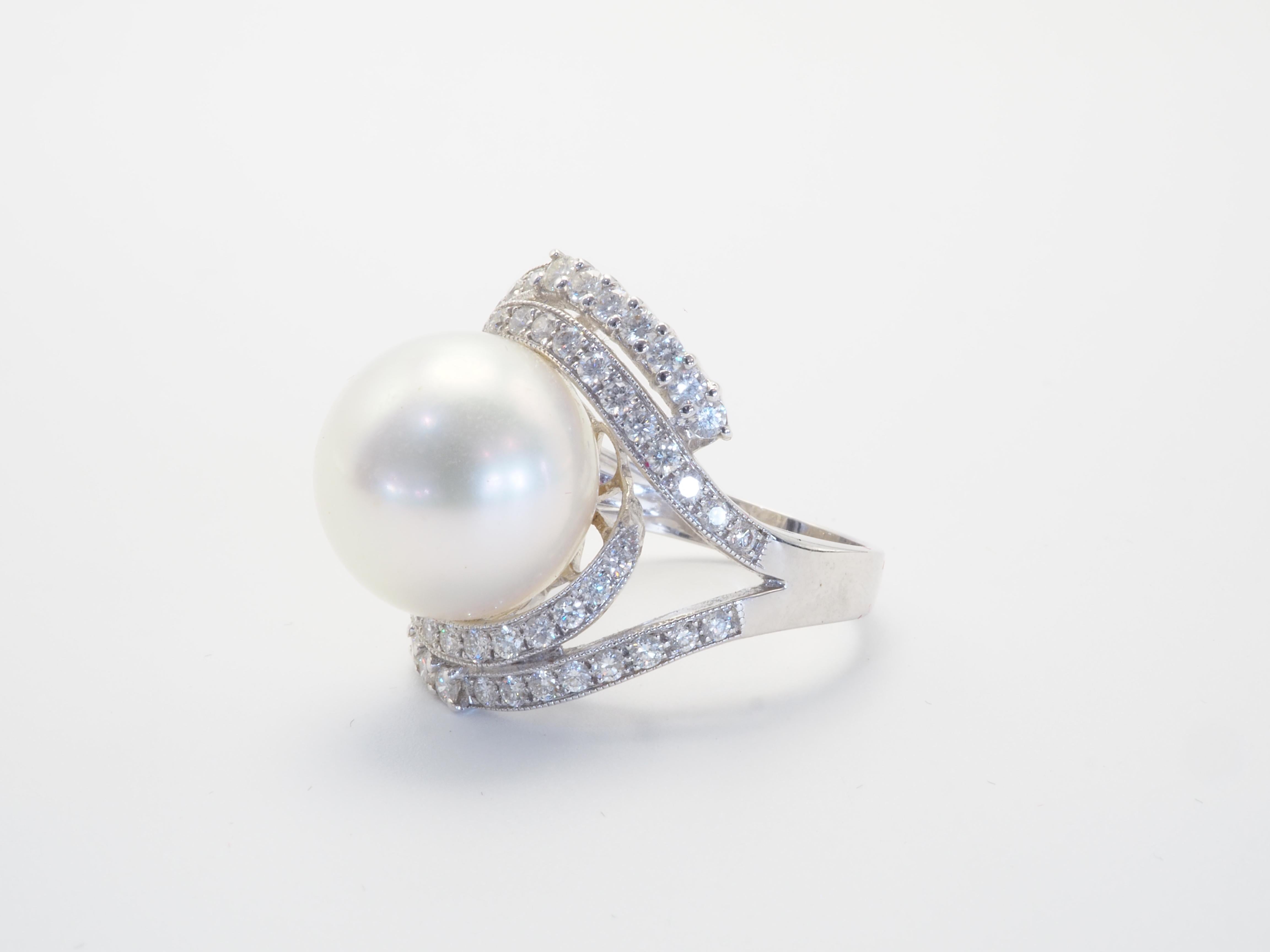 This brilliant 18k with gold ring is adorned with a rare and beautiful South Sea pearl! The pearl is perfectly round and has some visible blemishes as seen in the first picture. The diameter of the pearl is around 13.50mm. The accenting diamonds are