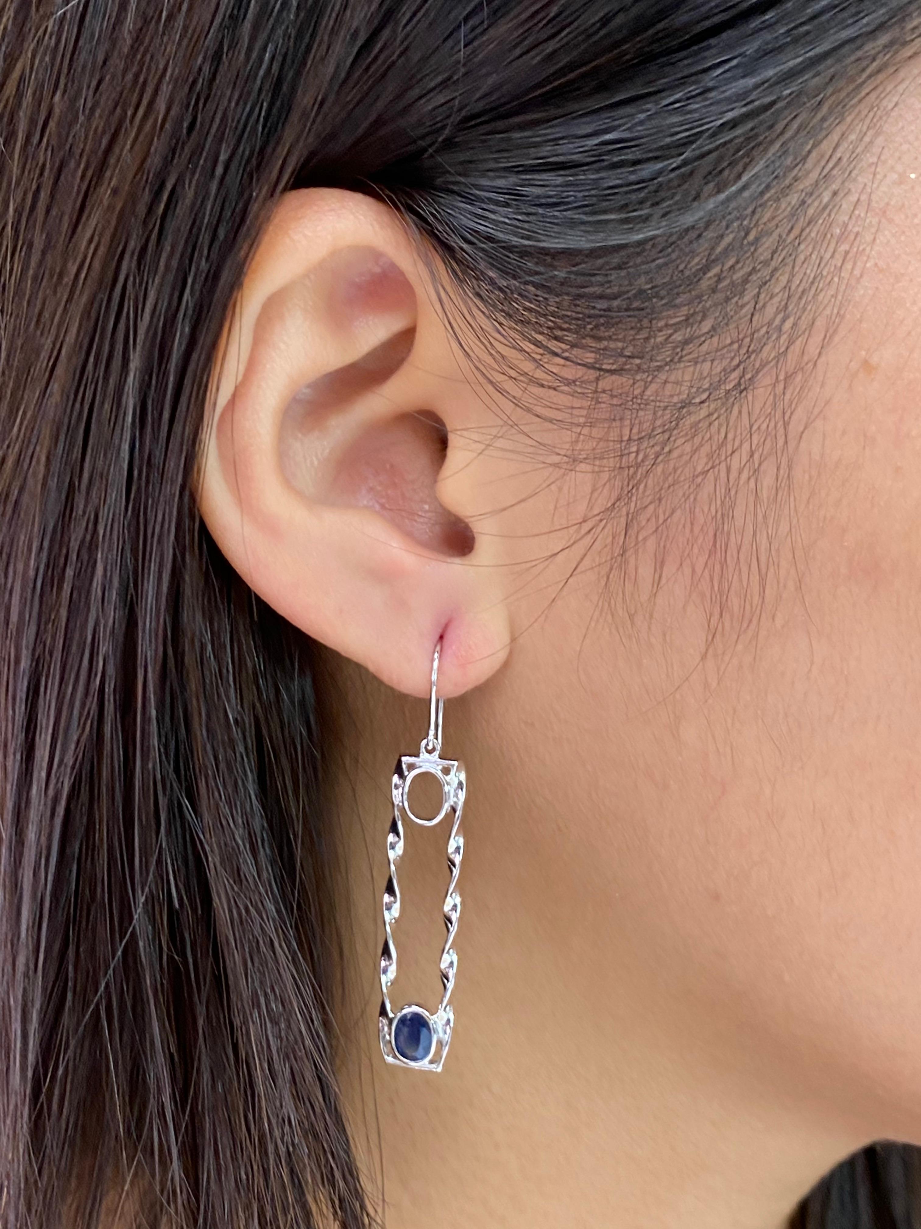 Here is a very nice pair of Sapphire drop earrings. The design is superb. The earrings are set in 18k white gold. Unique with a twist. The 2 oval shaped sapphires weight a total of 1.45cts. You can spot these drop earrings from far away. You can't