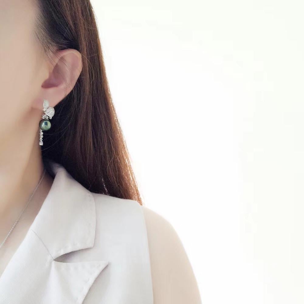 A breathtaking blend of nature-inspired elegance and luxurious craftsmanship, these Peacock Green Tahitian Pearl Earrings are a timeless statement piece. Featuring lustrous high-luster Tahitian pearls, their deep green iridescence captivates with