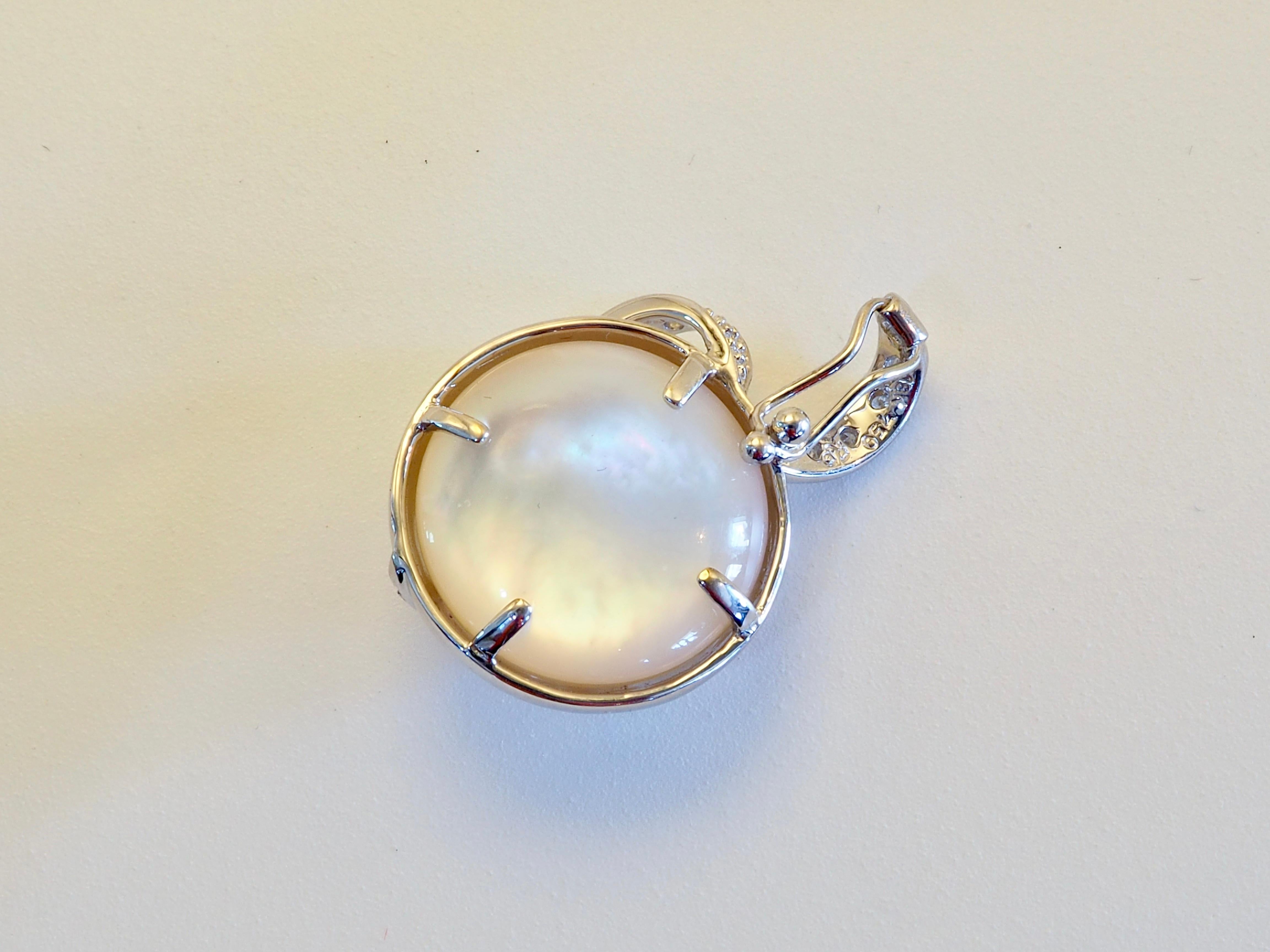 Célébration radieuse de l'élégance et du savoir-faire, ce pendentif présente une perle Brilliante de 14 mm sertie en or blanc 18 carats, entourée d'un gracieux tourbillon de diamants brillants de 0,14 carat. Le Design/One évoque le mouvement et la