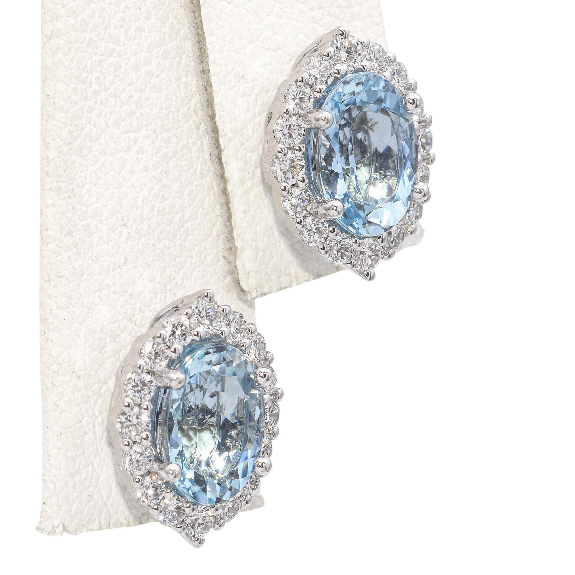 Questi eleganti orecchini a perno sono caratterizzati da vivaci acquemarine con taglio a marquise, incorniciate da una scintillante aureola di diamanti, il tutto incastonato in oro bianco lucido 18 carati. Il design raffinato mette in risalto il blu