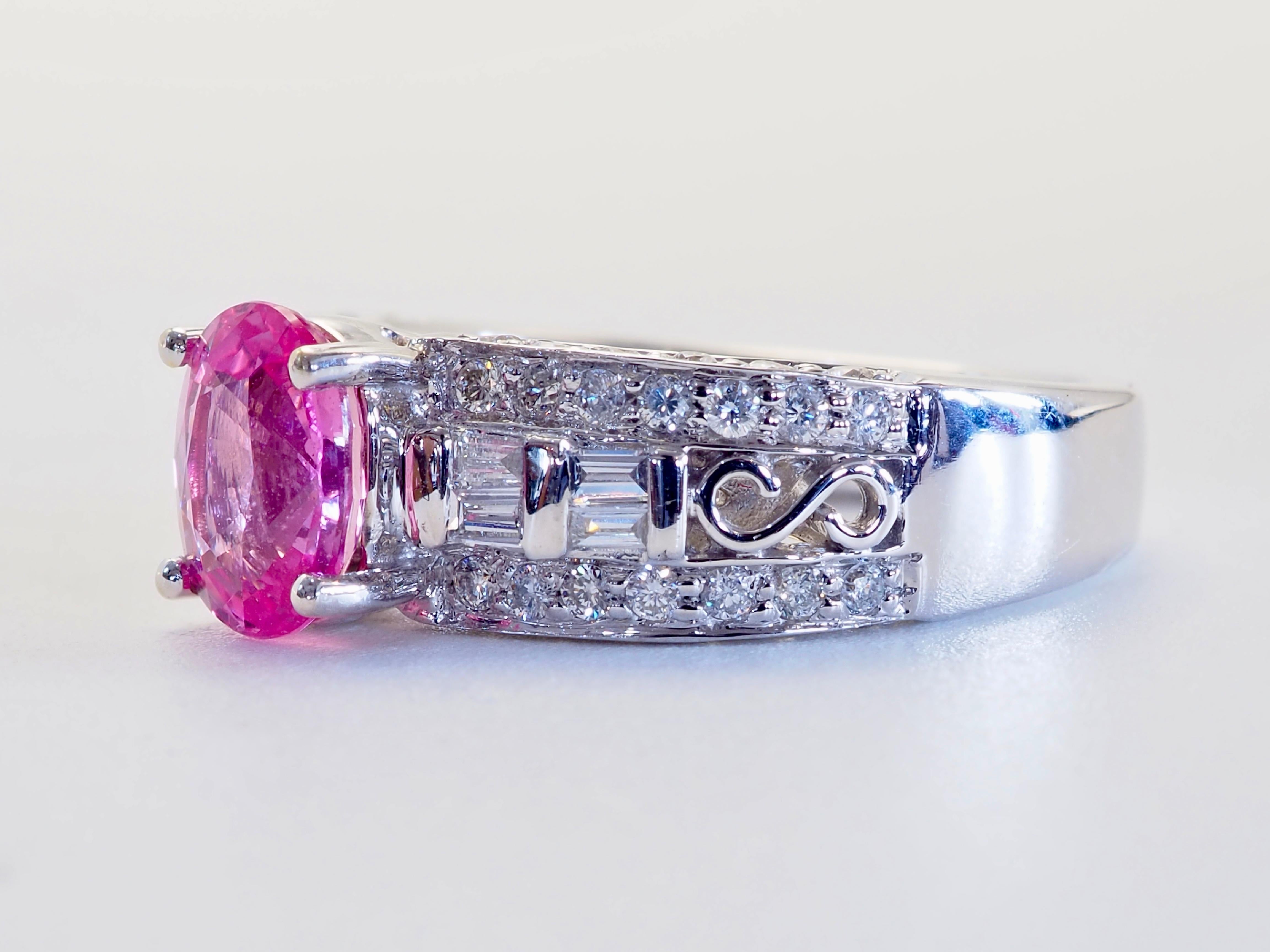 Anello di alta gamma con uno splendido e raro zaffiro rosa come pezzo centrale. Decorato con numerosi diamanti a baguette e brillanti di alta qualità su tutta la fascia e sul lato della corona. Incisioni del marchio del designer di Hong Kong su