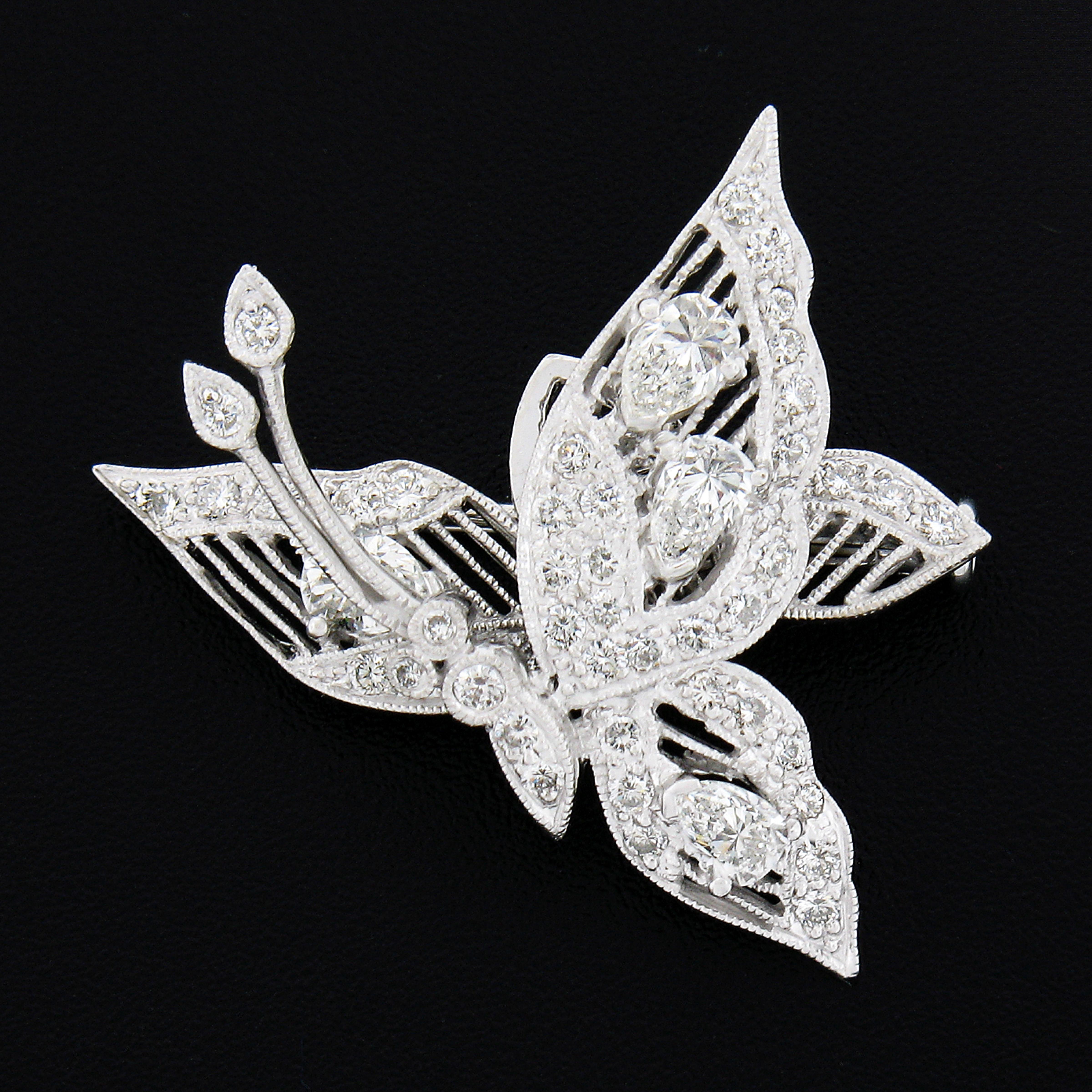 This gorgeous and elegant en Tremblant style pin brooch was beautifully designed and crafted from solid 18k white gold. The brooch features an amazingly detailed open work butterfly design adorned with delicate milgrain etching and is set with very