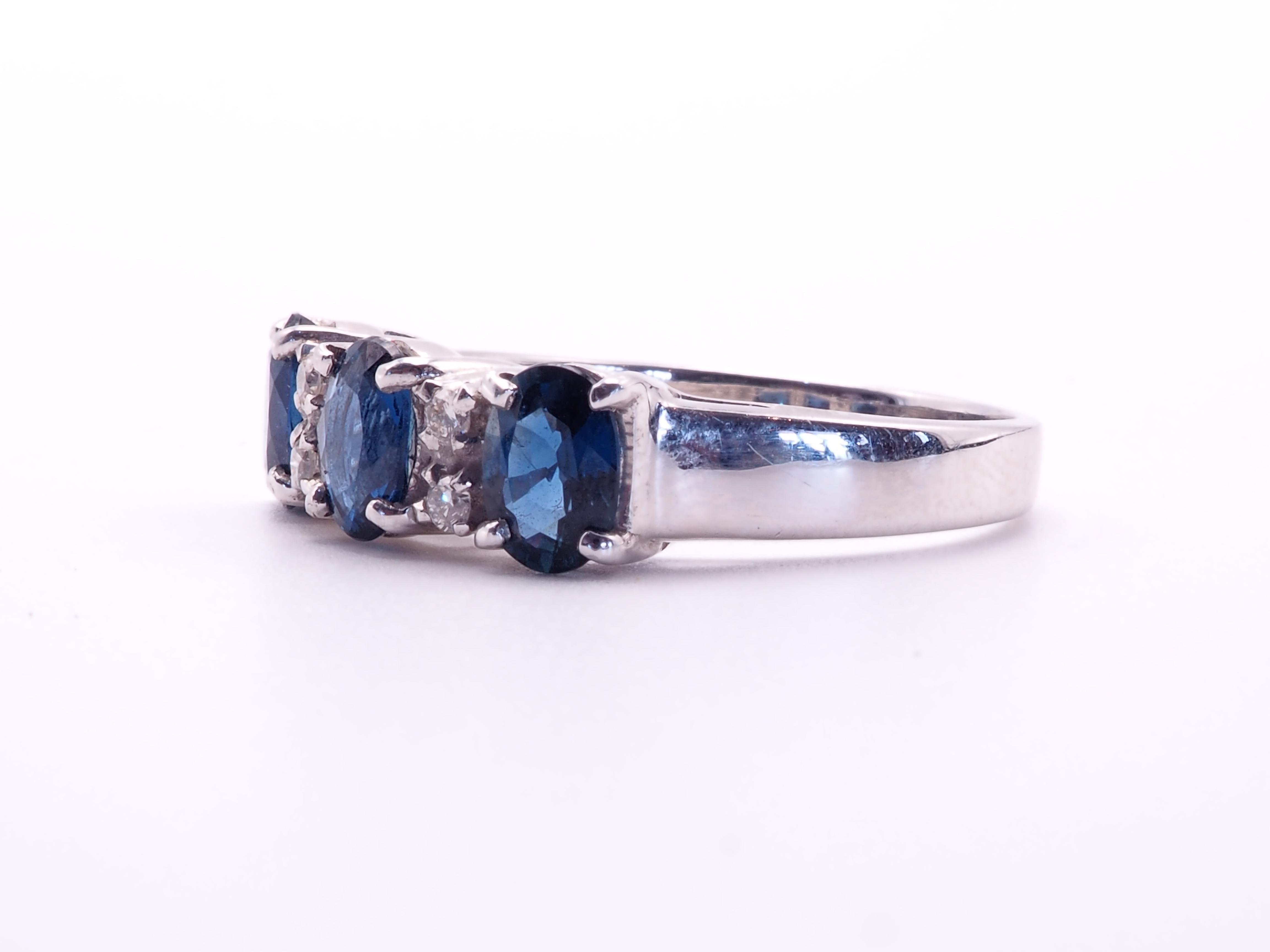 This quality and beautiful engagement piece is an 18K white gold fine quality oval blue sapphire and diamond ring. 3 fiery oval blue sapphires are set meticulously and all the same size with matching colors. There are 4 of round cut diamonds which