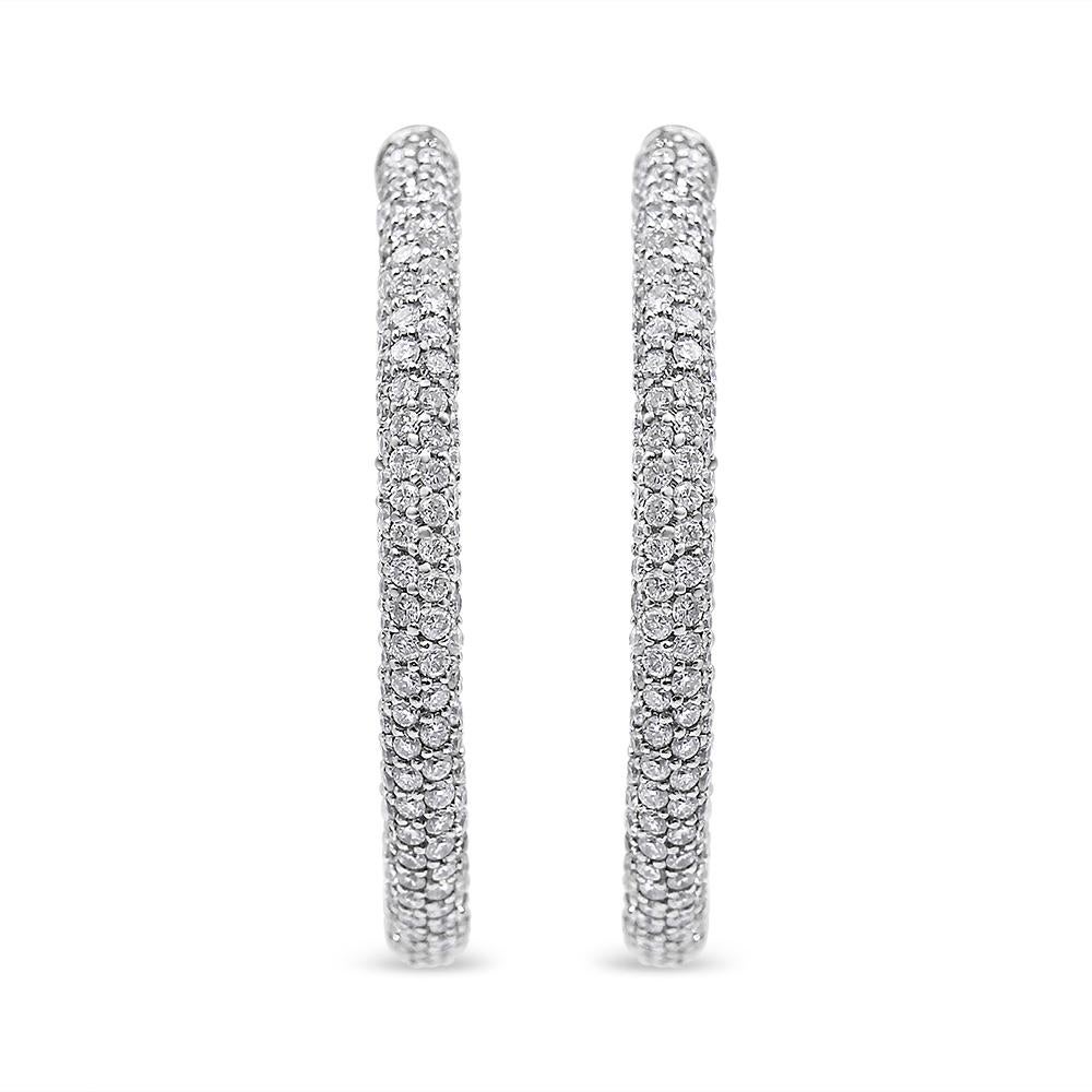 A dewy oval silhouette drips with French pavé-set diamonds giving these 18k white gold hoop earrings a dazzling modern look that commands attention with their subtle light. These stunning semi-eternity hoop earrings feature 400 natural diamonds