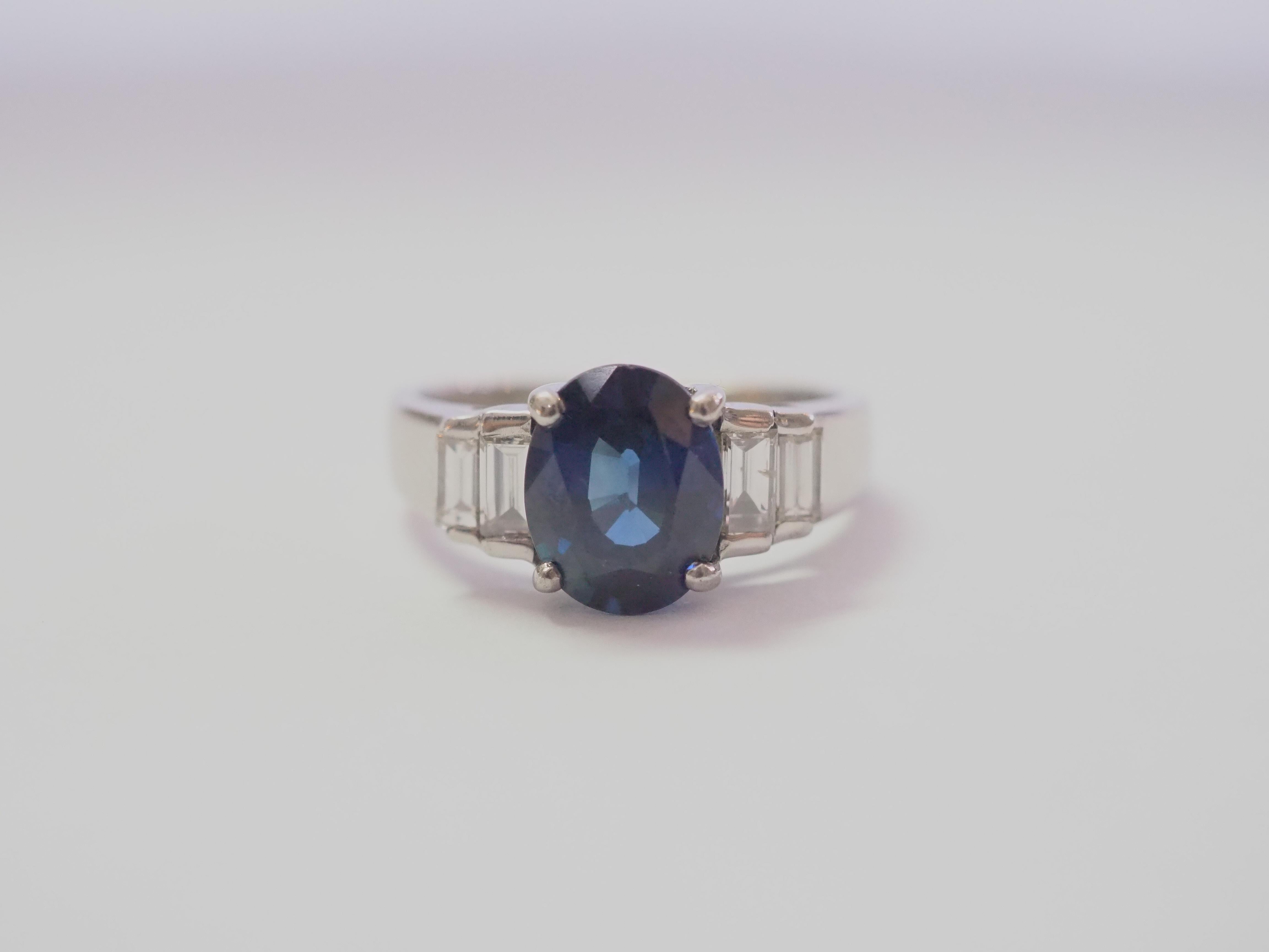 A finely crafted sapphire and diamond engagement ring. The 2.10 carats oval blue sapphire is eye clean and has dark tone and medium color saturation but is very vibrant and lively. The cut is perfect as well. 

The diamonds are bright and white with