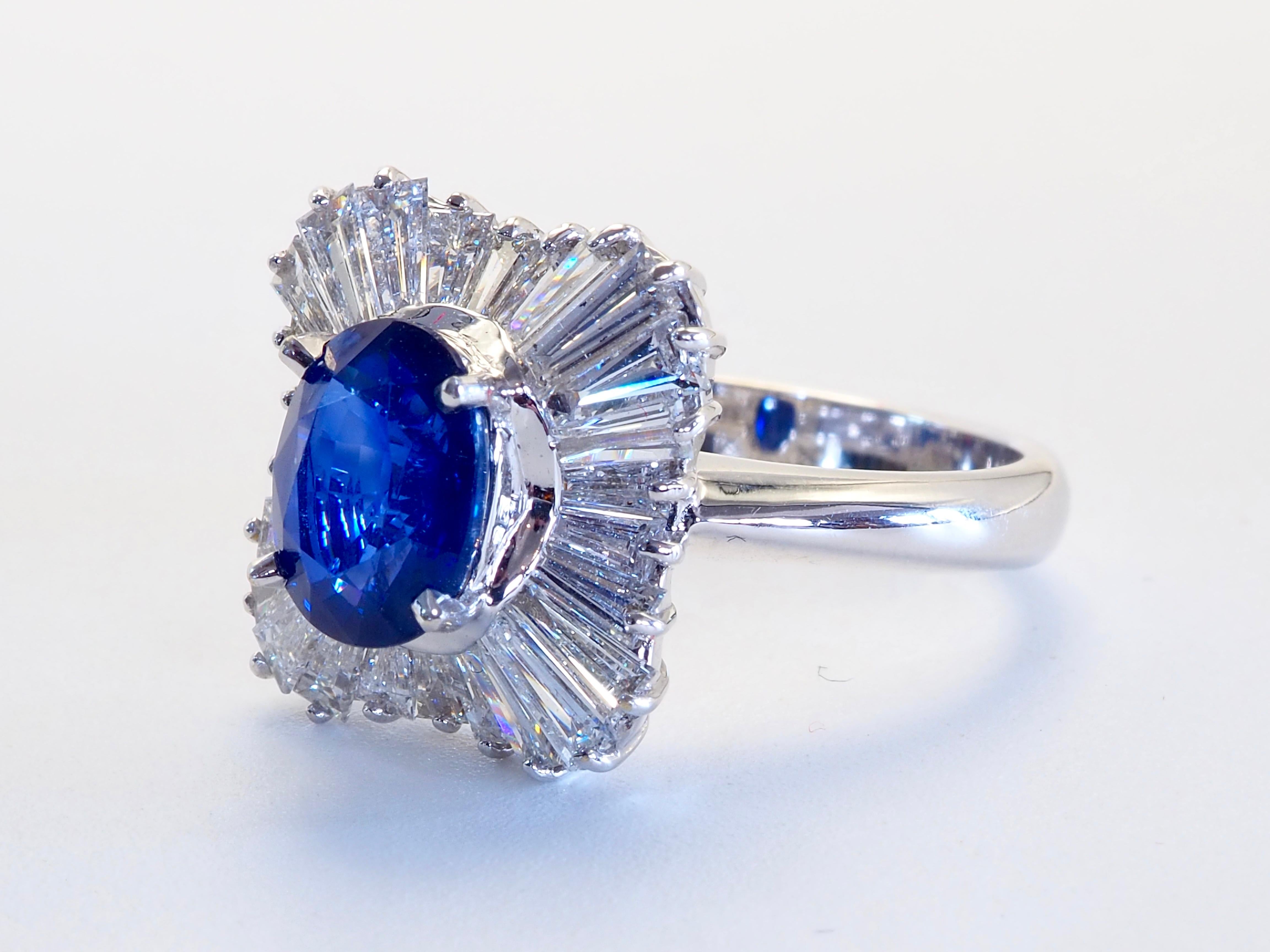  This amazing vintage ballerina statement ring boasts an oval vivid blue sapphire of 2.10 carats. The stunning oval cut sapphire is heavily surrounded by high grade natural tapered baguette cut diamonds. Immaculate craftsmanship can be seen in very