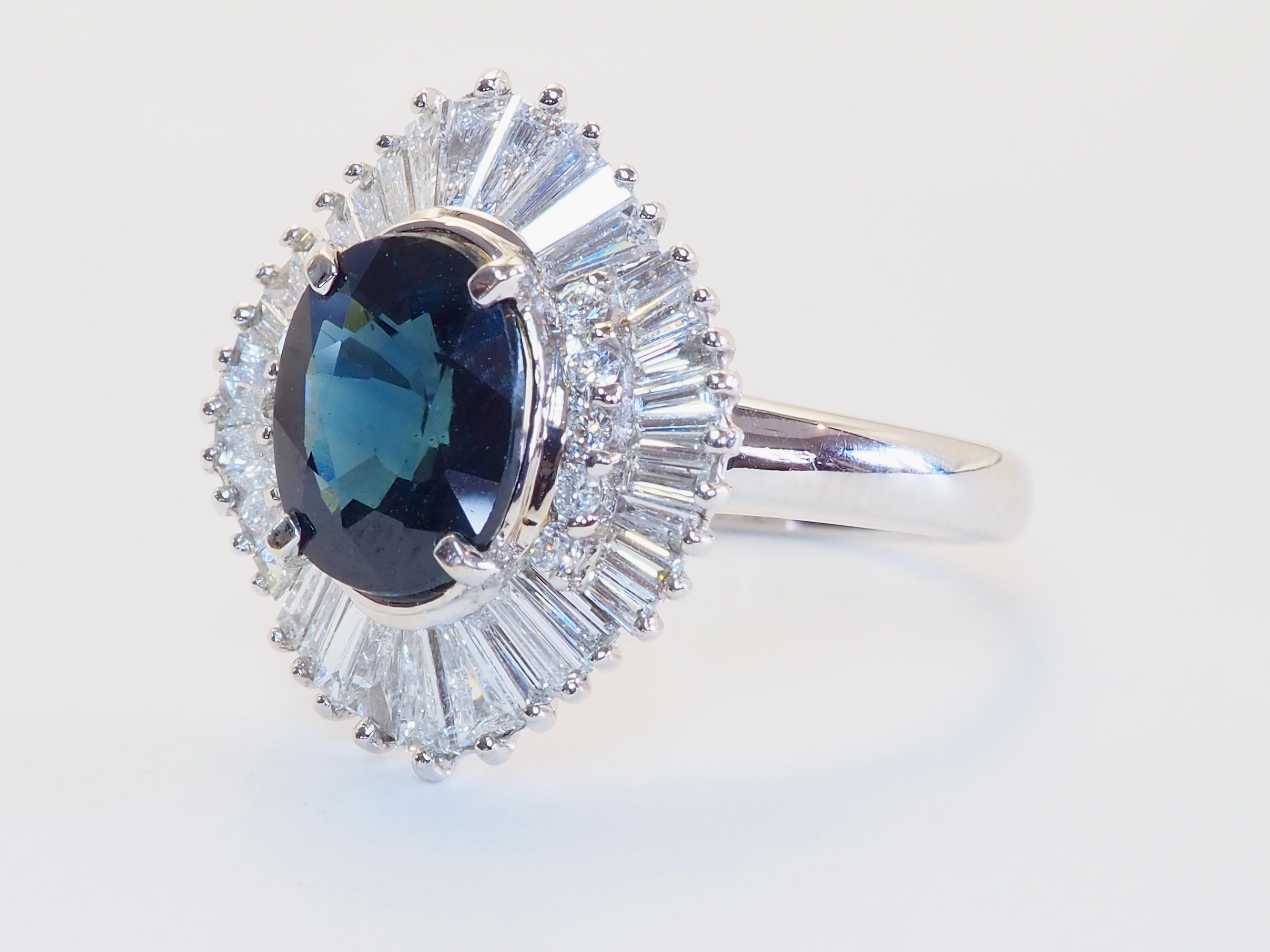 Dieser feine Ballerina-Ring ist ein fesselndes Statement für Eleganz und Erbe. Er ist mit einem seltenen thailändischen Saphir im Ovalschliff von 2,24 Karat in einem faszinierenden, tief grünblauen Farbton besetzt - ein außergewöhnlicher Stein, der