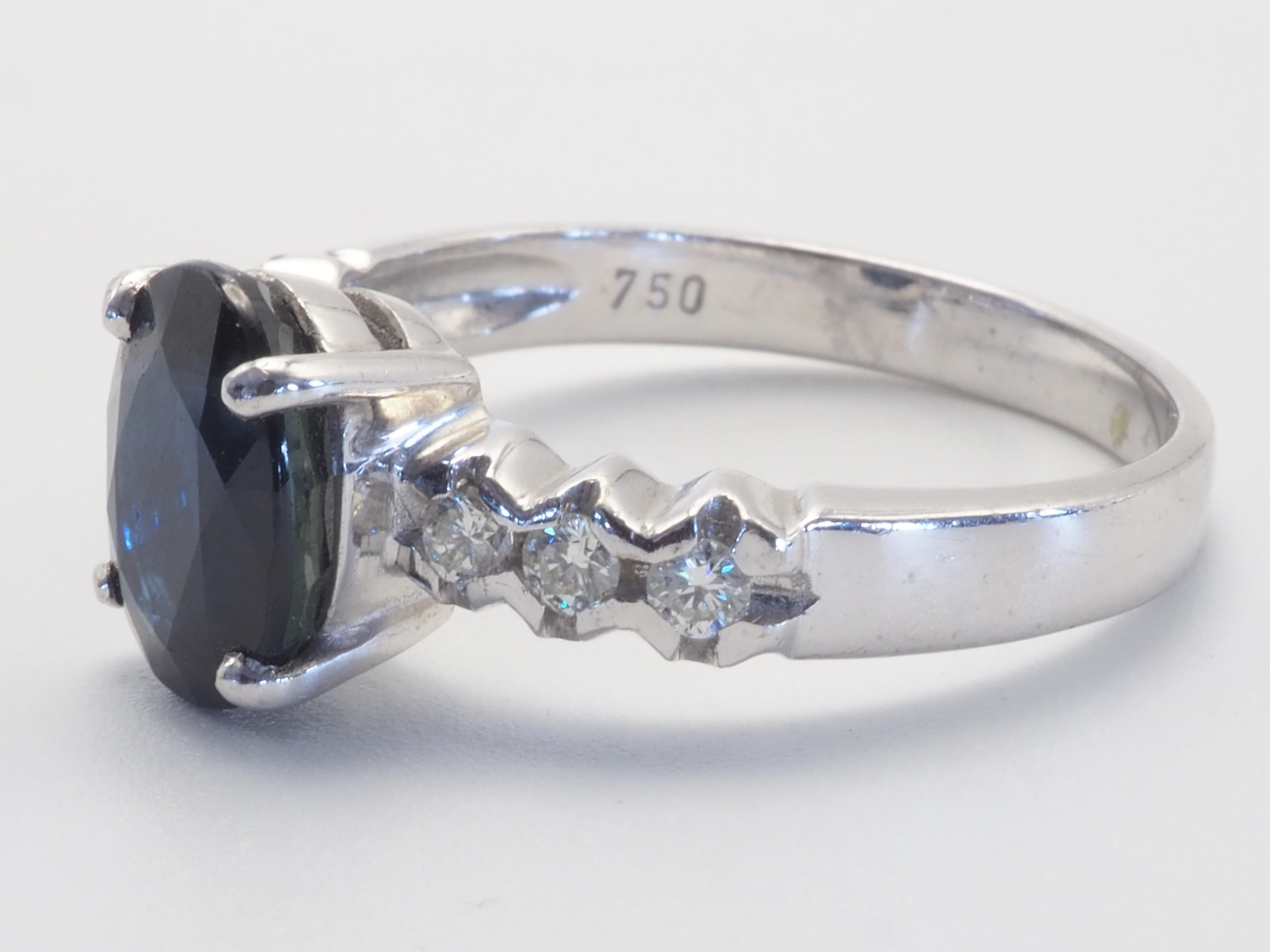 A stunning Thai inky blue sapphire ring. Some may dislike the inky tone but some may find it something special about this color. The blue sapphire has a bit of inky tint with diagonal silk inclusions visible across table- it adds to the uniqueness