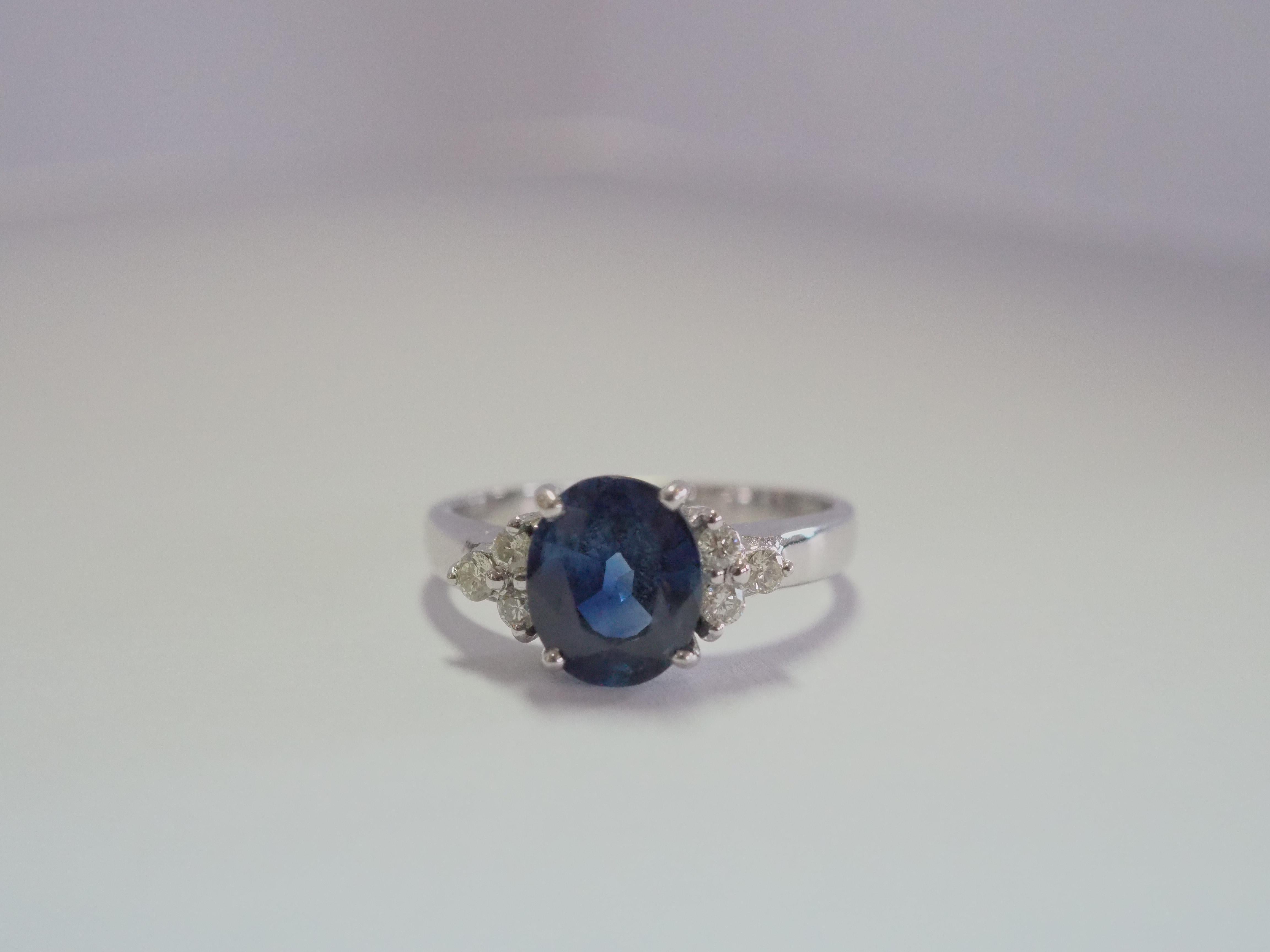 A stunning Thai blue sapphire ring. The blue sapphire has a bit of green tint but is very clean with no visible eye inclusions. The diamonds here are brilliant and of very good quality, clear and colorless. Set in beautiful mount of 18k solid white