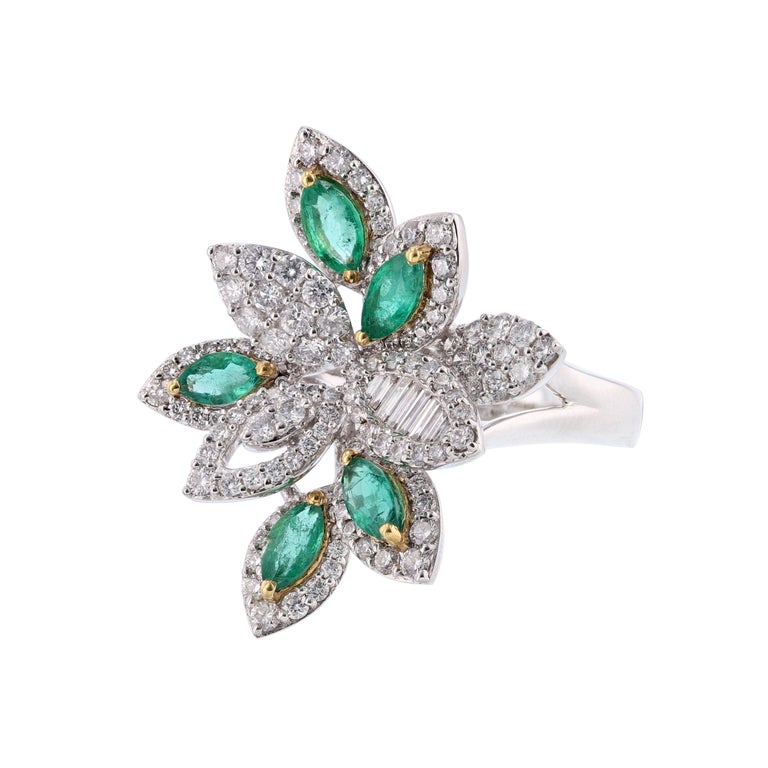 This ring is 18K white and yellow gold and features 5 marquise cut emeralds weighing 1.27 carats. It also features 139 round and baguette cut diamonds weighing 1.40 carats. The stones are all set with prongs. With a color grade (H) and clarity grade