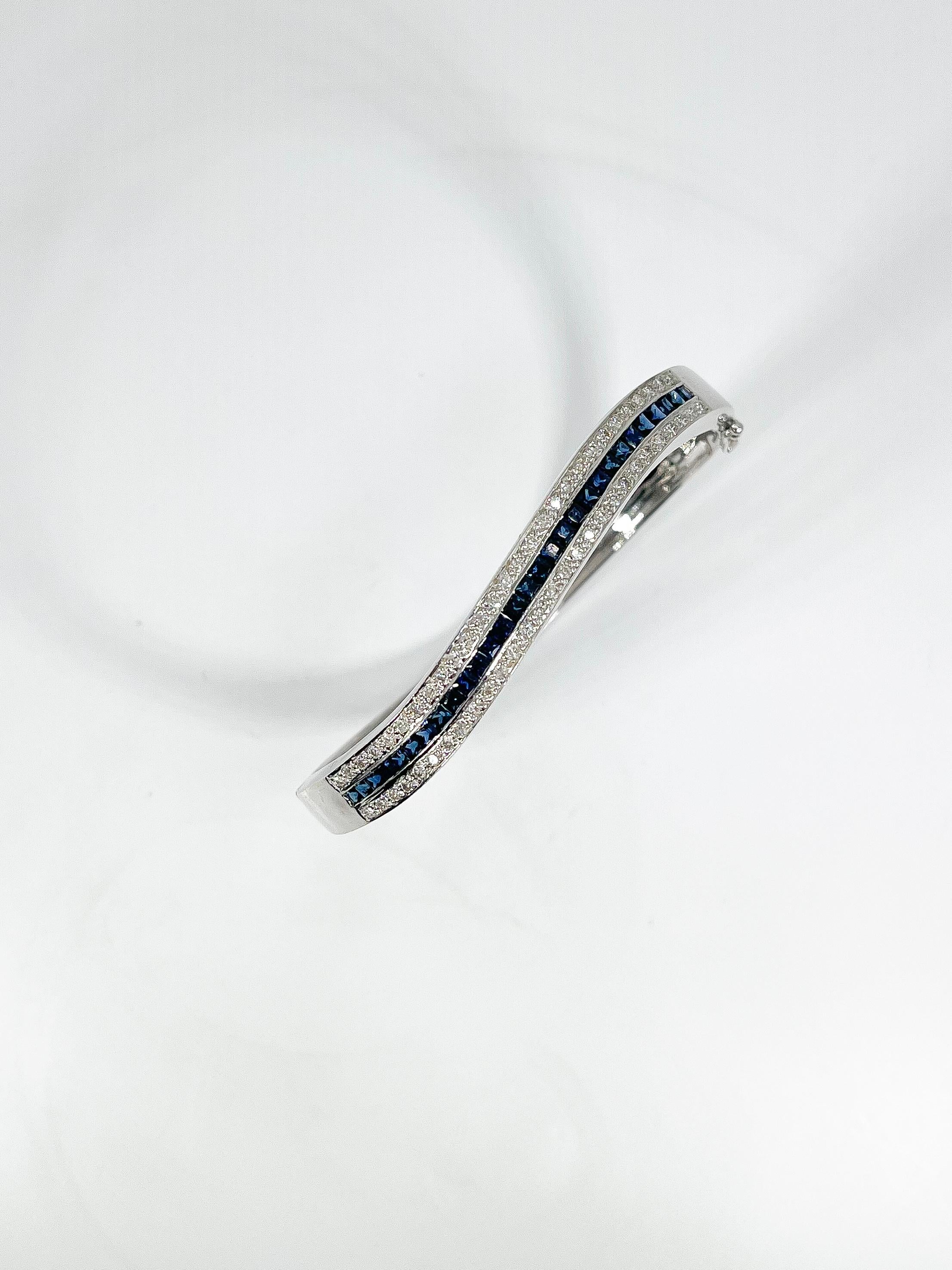 18k white gold 2 CTW sapphire and 1 CTW diamond bangle. All of the diamonds in the bracelet are round and the sapphires are princess cut. The width of the bracelet is 7.1 mm and it has a total weight of 20.69.