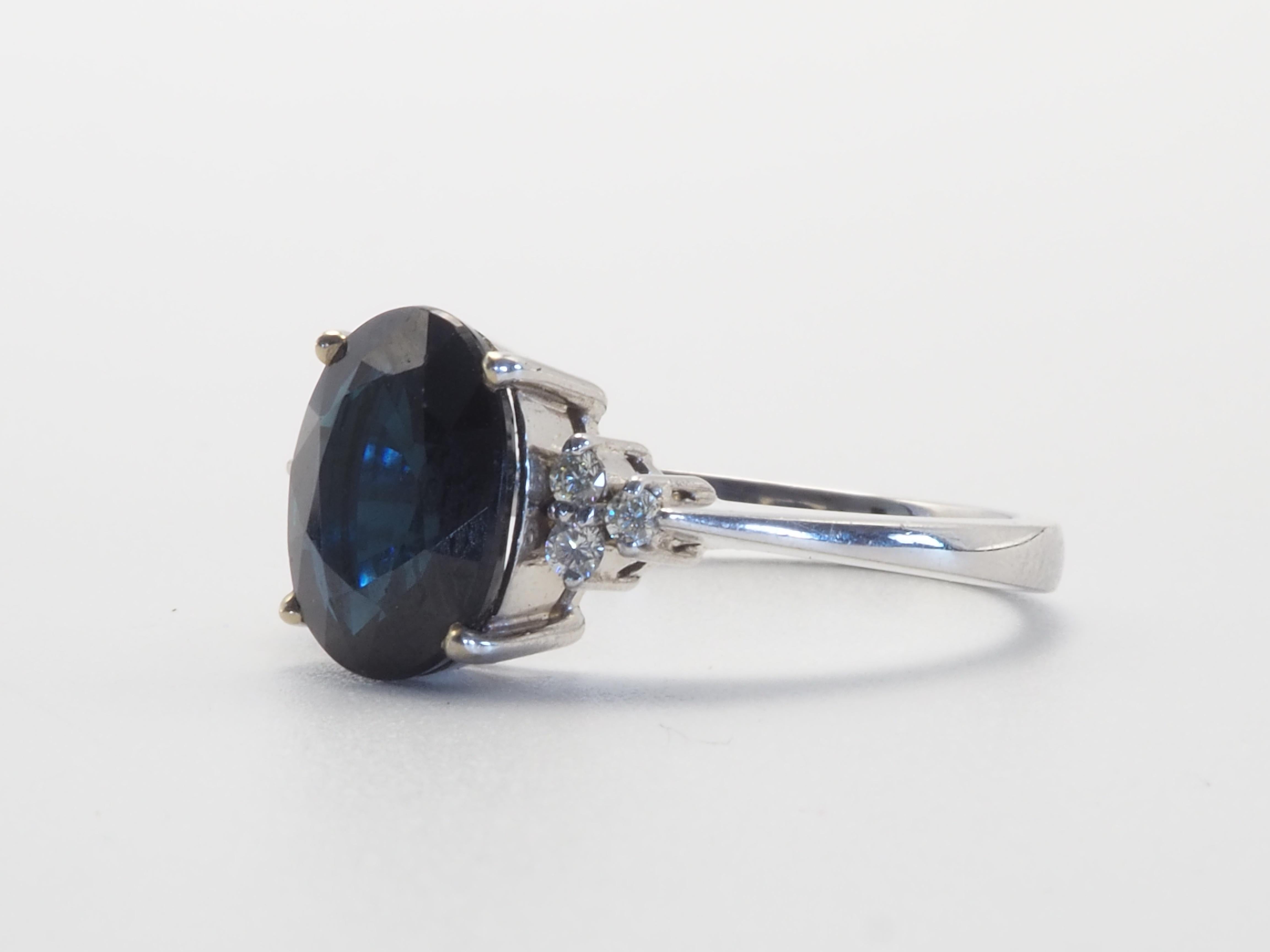 A stunning Thai blue sapphire ring. Some may dislike the inky tone but some may find something special about this color. The blue sapphire has a bit of inky tint but is very clean eye with minimal inclusions- the table is clean. The diamonds here