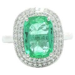Bague en or blanc 18k 3.6ctw GIA émeraude coussin allongée avec double halo de diamants