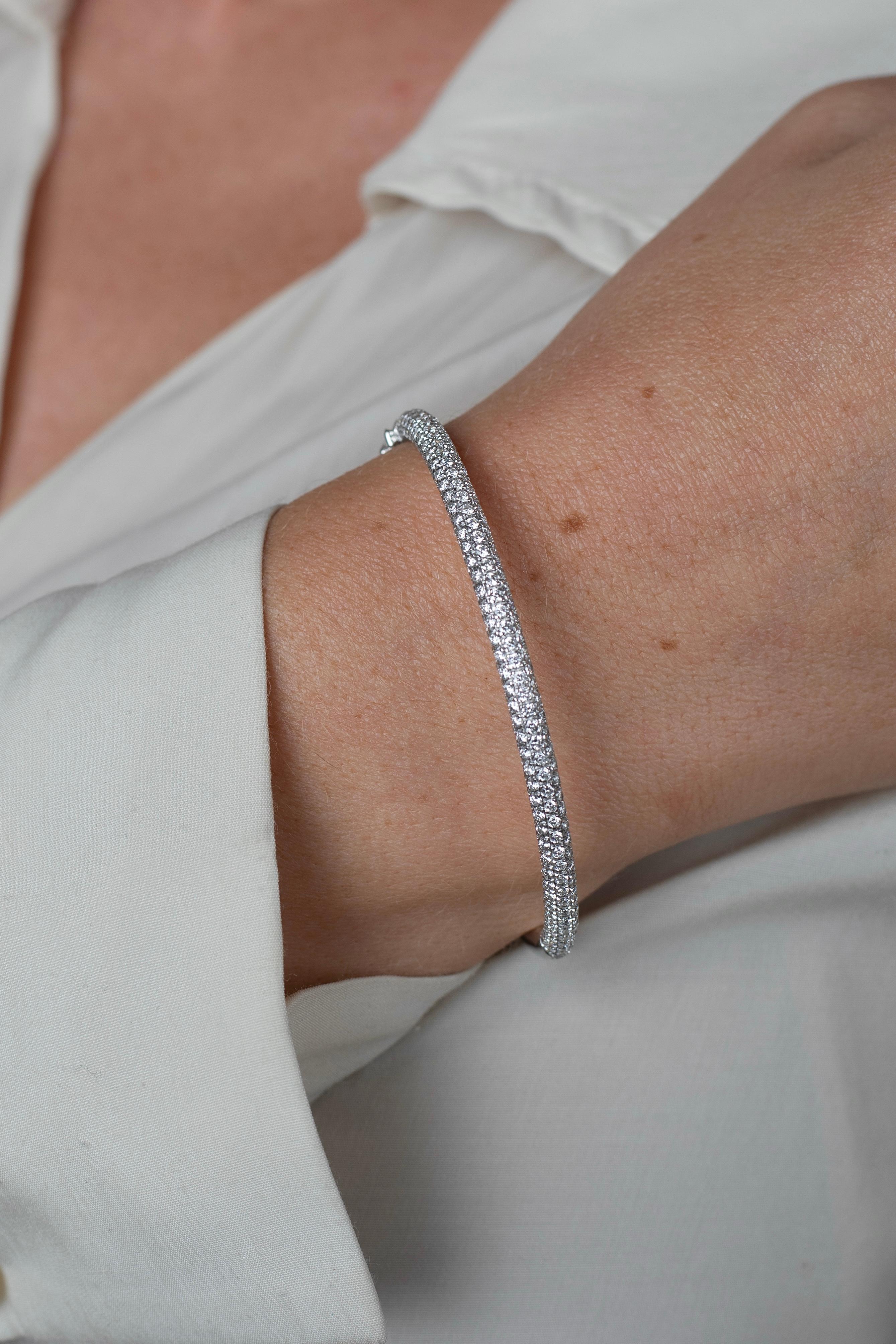 Micro pave set round brilliant cut natural diamonds mount this stunning 18 karat white gold bangle bracelet. Handmade with a box closure and double safety for a secure fit, making it ideal for daily wear. Waterproof, hypoallergenic, and meticulously