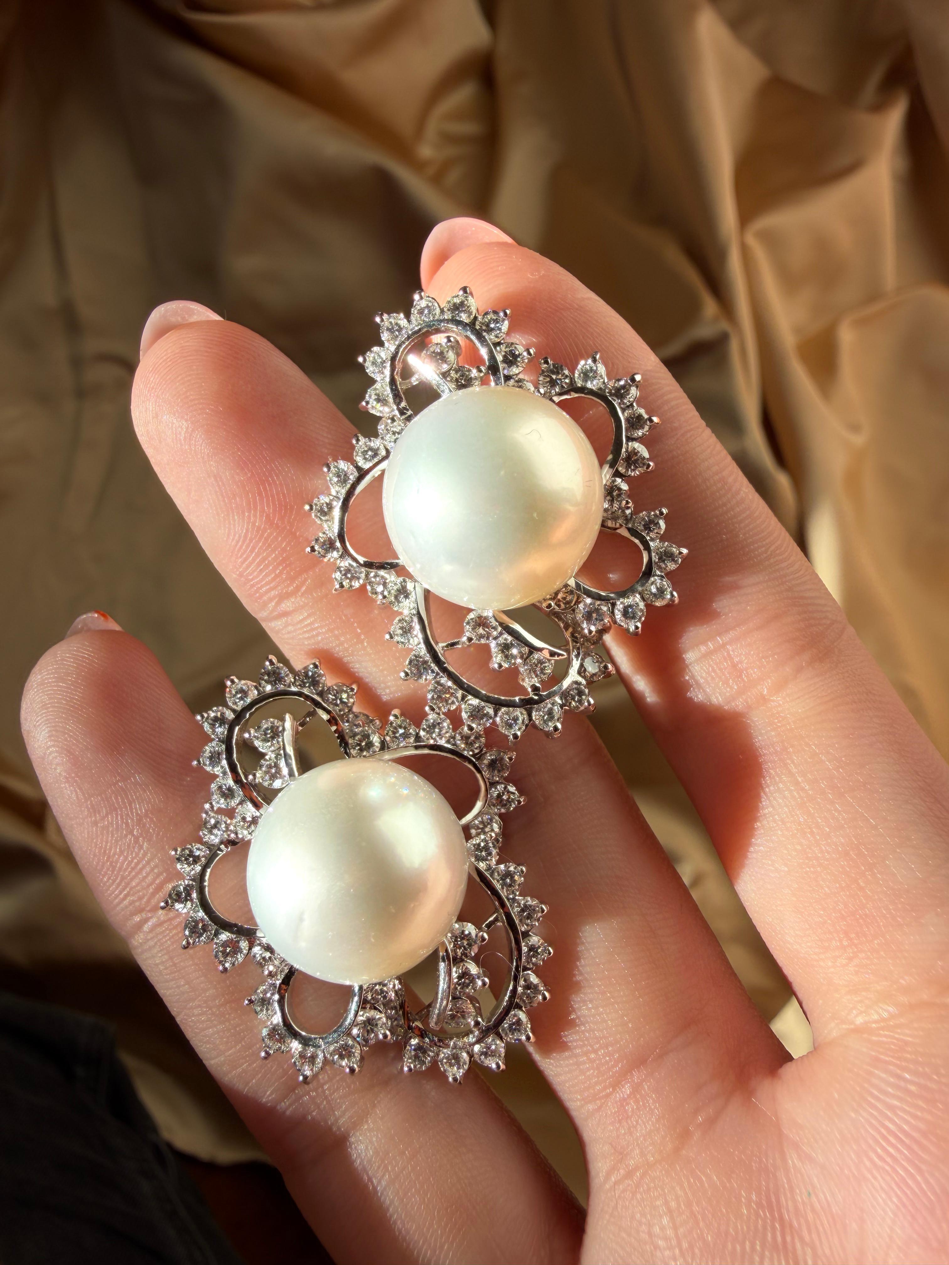 Ces remarquables boucles d'oreilles en or blanc 18 carats présentent de grandes perles de culture des mers du Sud de 15,30 mm encadrées par 4,16 carats de diamants étincelants. Leur design floral ajouré leur confère une allure à la fois audacieuse