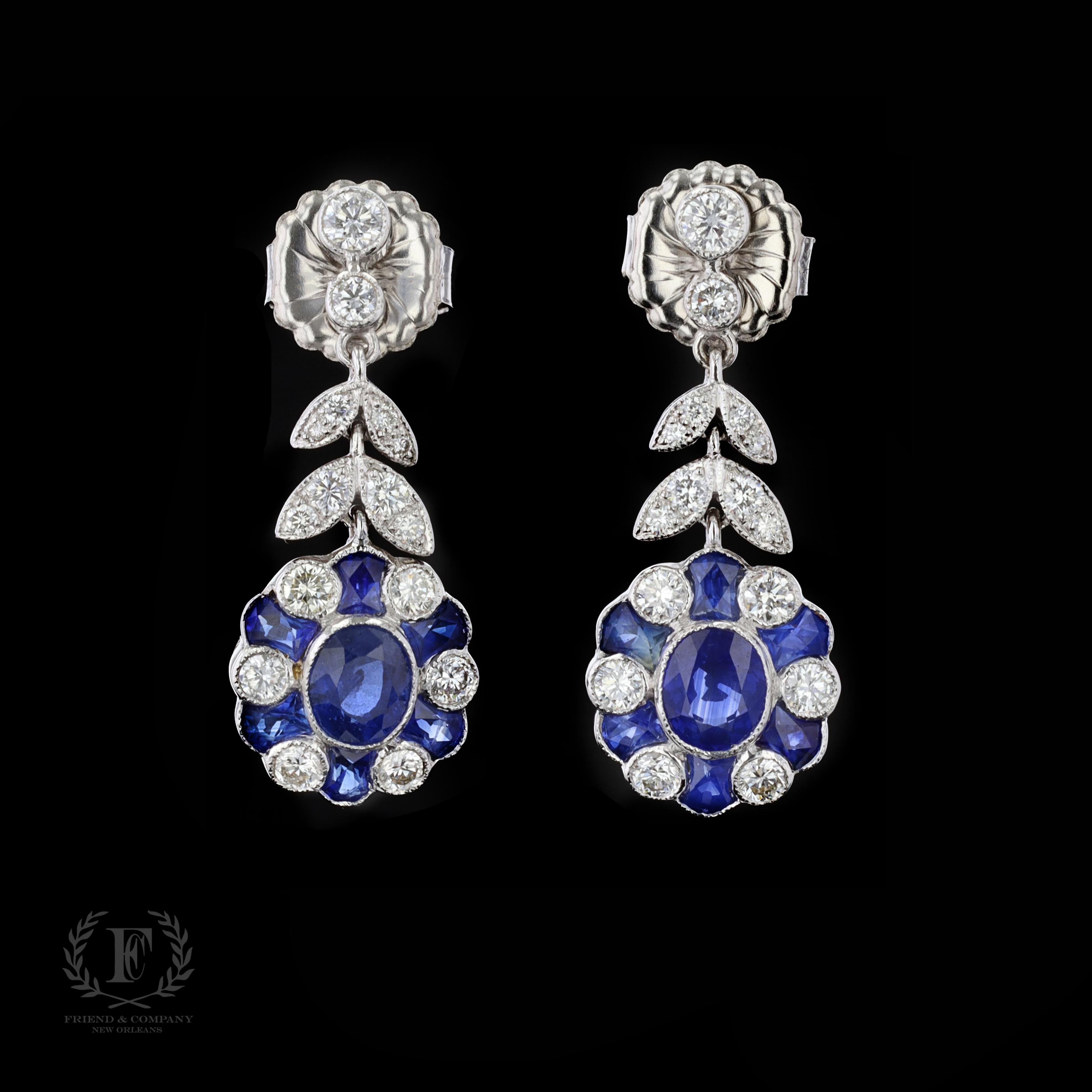 The earrings feature oval and modified faceted blue sapphires that weigh approximately 5.00 carats. The sapphires are accentuated by sparkling round cut diamonds that weigh approximately 1.60 carats. The color of the diamonds is H with VS clarity.