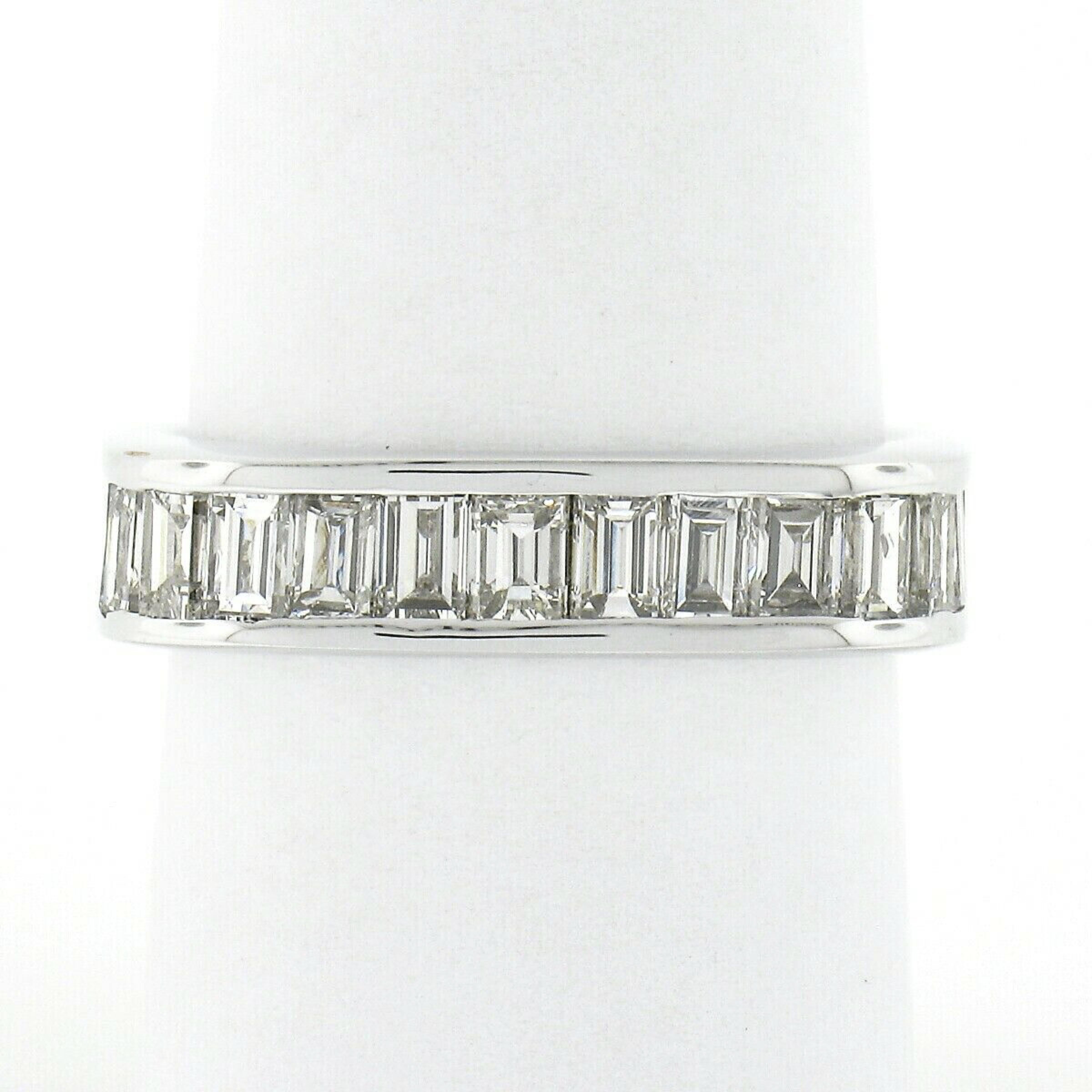 This absolutely stunning and very well made diamond eternity band is crafted in solid 18k white gold and features very fine quality straight baguette cut diamonds neatly channel set entirely throughout the squared design. The ring contains 34