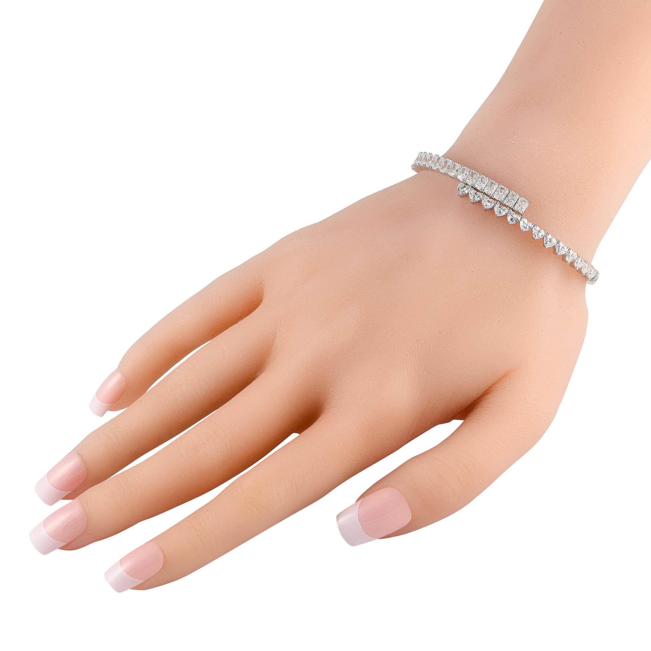 A dynamic wrapped design makes this sleek 18K white gold bangle bracelet anything but ordinary. Elevated by heart-shaped diamonds totaling 2.50 carats and radiant-cut diamonds totaling 3.95 carats, this exquisite accessory will radiate light along