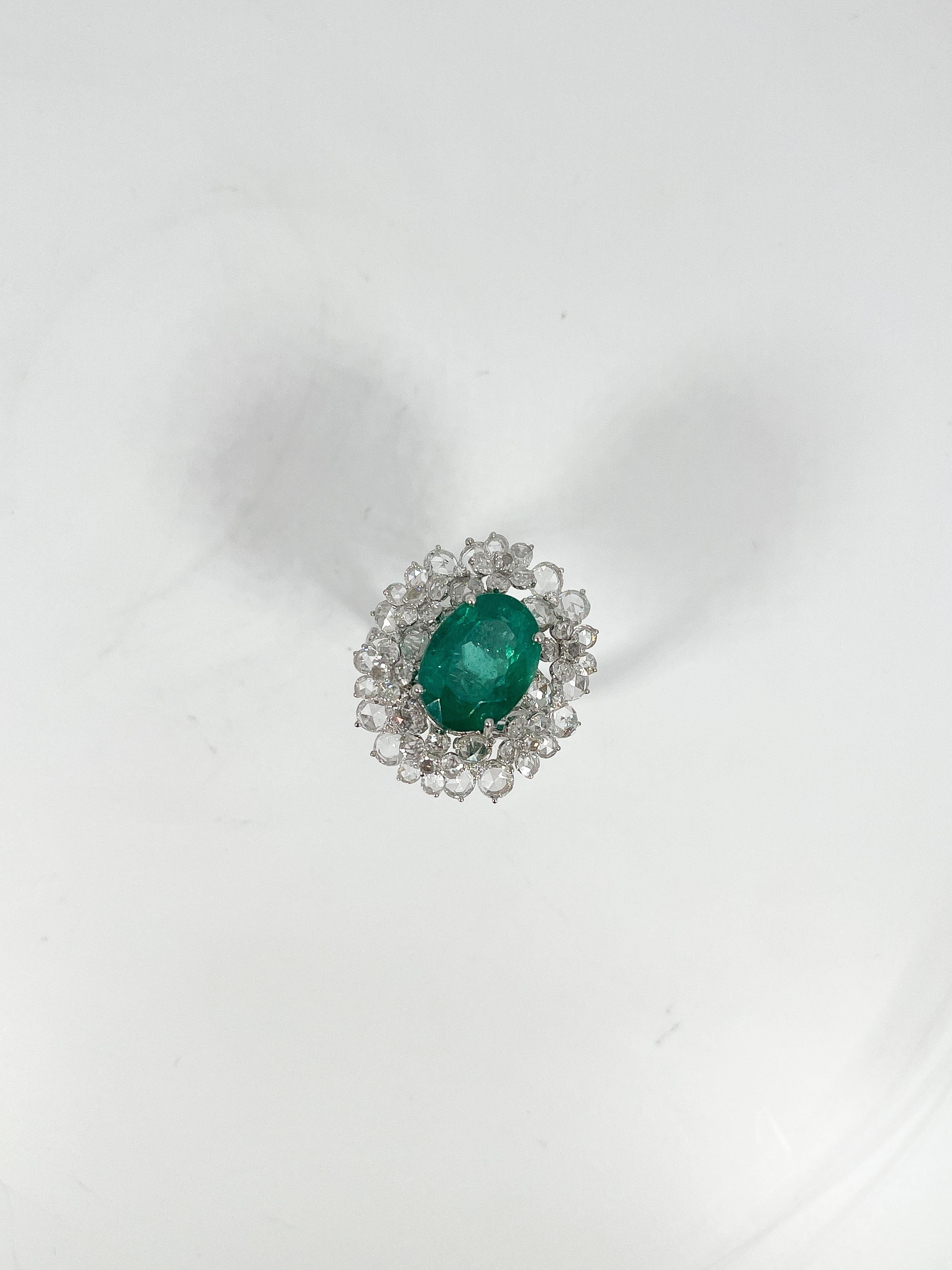 Anillo de oro blanco de 18 quilates, talla 7 1/4, engastado con una esmeralda ovalada talla brillante, diamantes redondos talla rosa y diamantes redondos talla brillante. El peso total del artículo es de 11,5 gramos. Viene con certificación