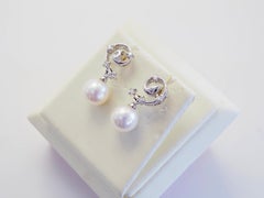 Boucles d'oreilles or blanc 18 carats perle de mer blanche 7,2 mm et diamant 0,12 carat motif mer pendante