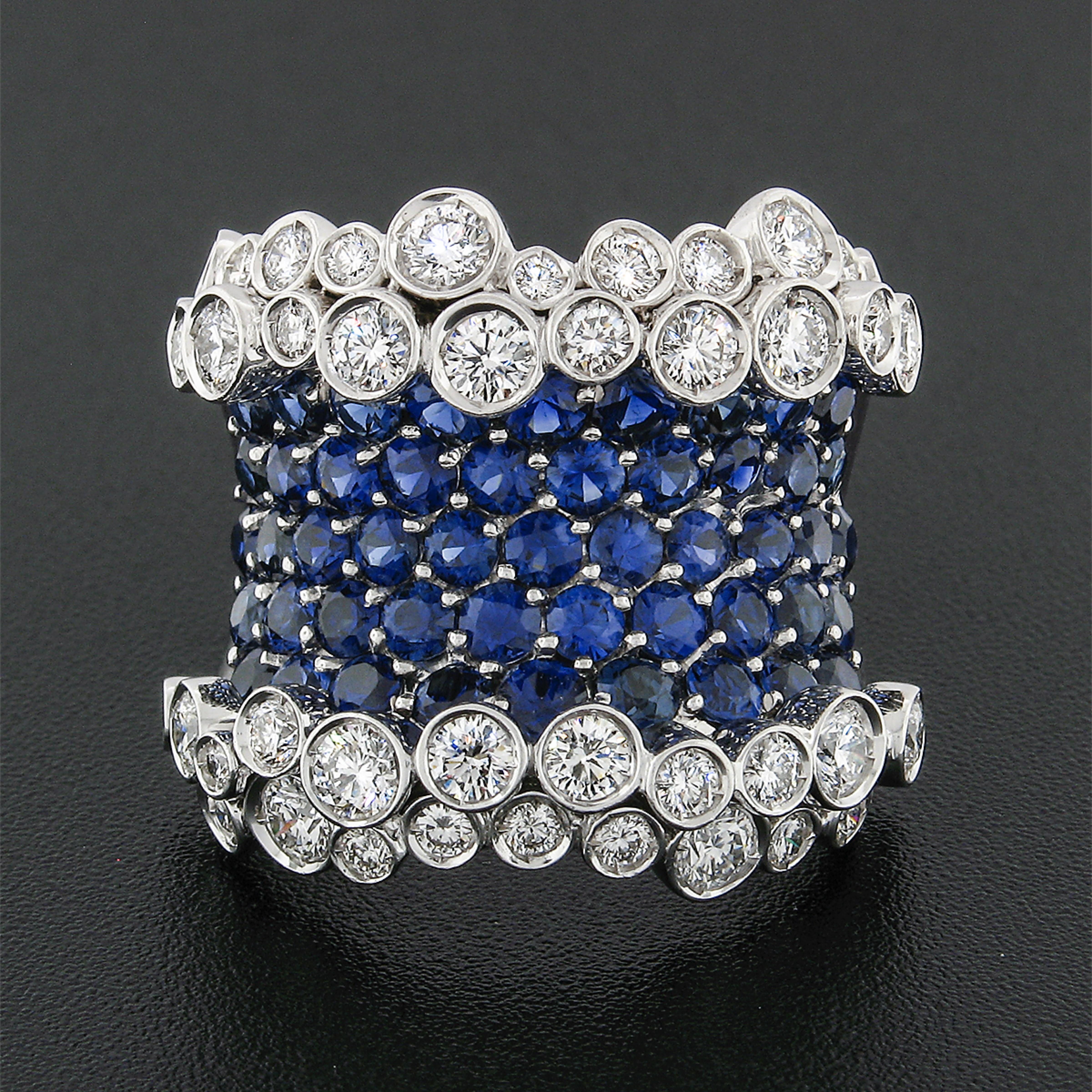 Here we have an absolutely magnificent cocktail ring designed by Stefan Hafner and crafted in Italy from solid 18k white gold. The ring features a unique wide design set with very fine quality round brilliant sapphires and diamonds throughout. The