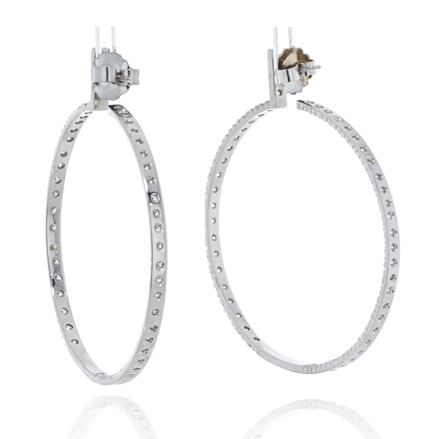 These glowing hoop earrings feature 9.25 total carats of diamonds in 18K white gold, finished with round cut diamonds mounted inside and out. 
2 inches wide this is a an earring that will stop traffic and will make you the star of the show. Long