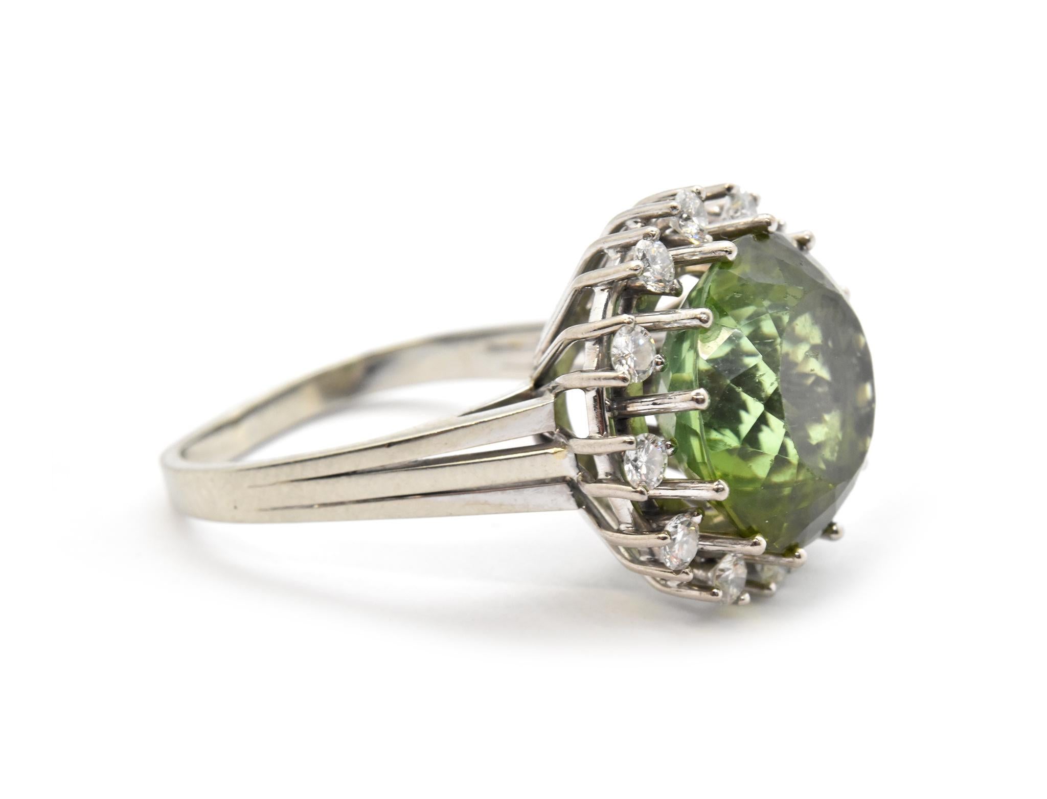 This stunning cocktail ring holds a fabulous green tourmaline at its center. The tourmaline weighs 9.87 carats, and it is surrounded by a halo of sparkling diamonds. The diamonds have an additional weight of 0.60ct total. The ring measures 18mm