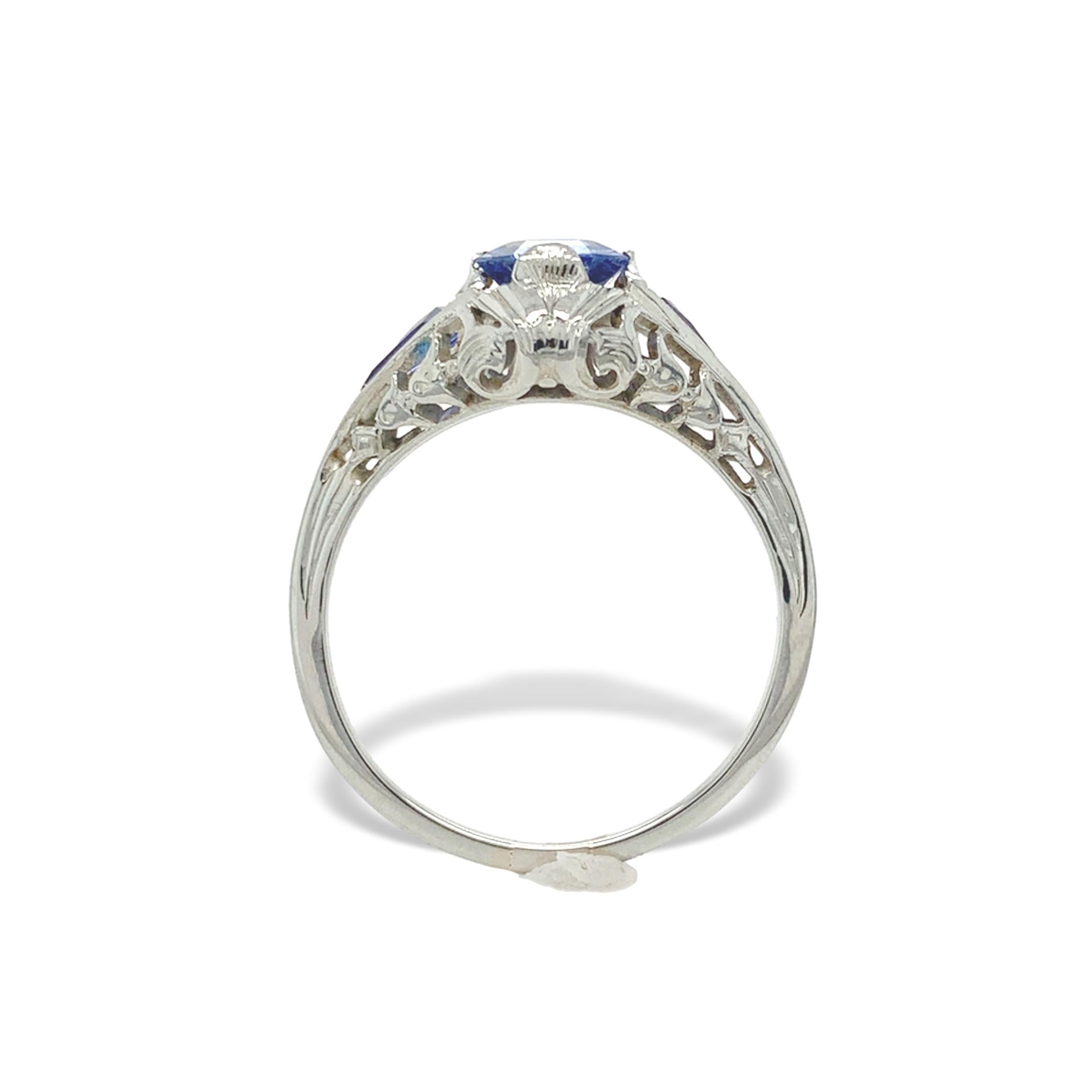 Anello in filigrana con zaffiro blu in oro bianco 18 carati. L'anello presenta un autentico zaffiro di Ceylon con taglio asscher estratto in terra. Misura circa 6 mm e pesa .98cts. Lo zaffiro ha un colore blu lavanda pervinca più chiaro. Ci sono 2