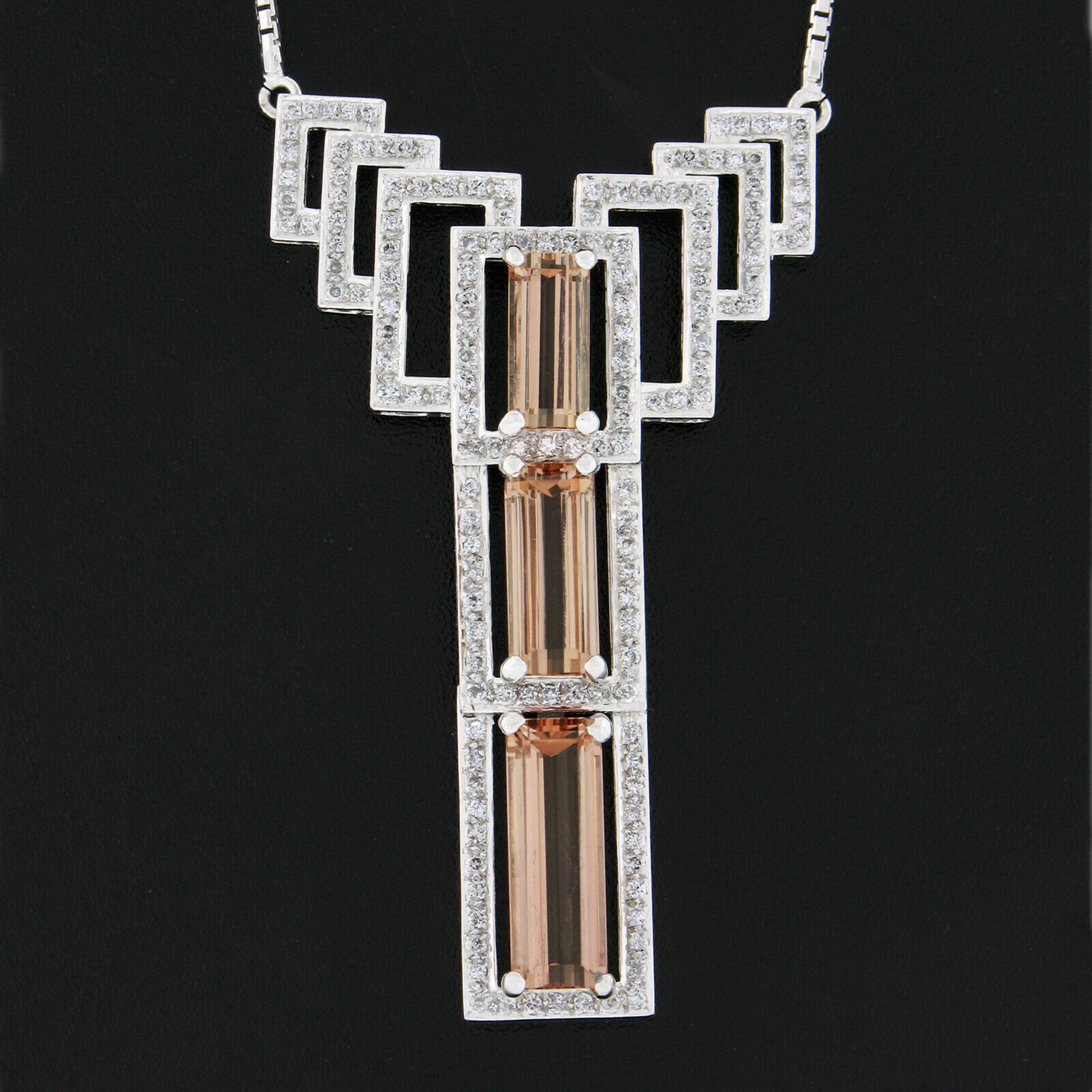 This magnificent pendant necklace is crafted from solid 18k white gold and features a large open work design drenched with very fine quality imperial topaz and diamonds throughout. The pendant carries three gorgeous imperial topaz stones, of which