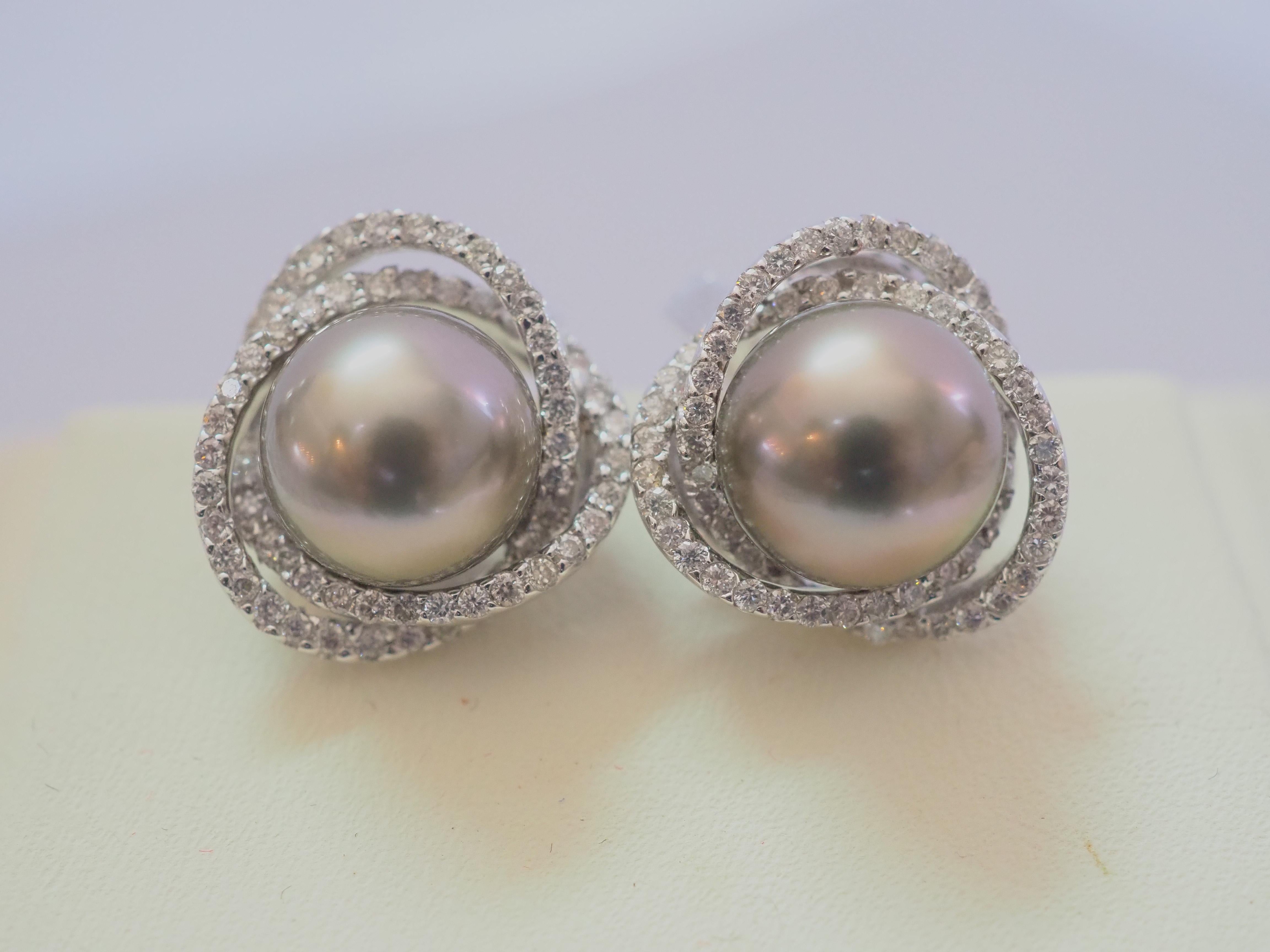 Presented here is a fine and gorgeous perfectly round and eye clean without blemishes with matching color which are of black Tahiti pearls. It is surrounded by two layers of round diamond stud earring. The brilliant round diamonds are genuine with