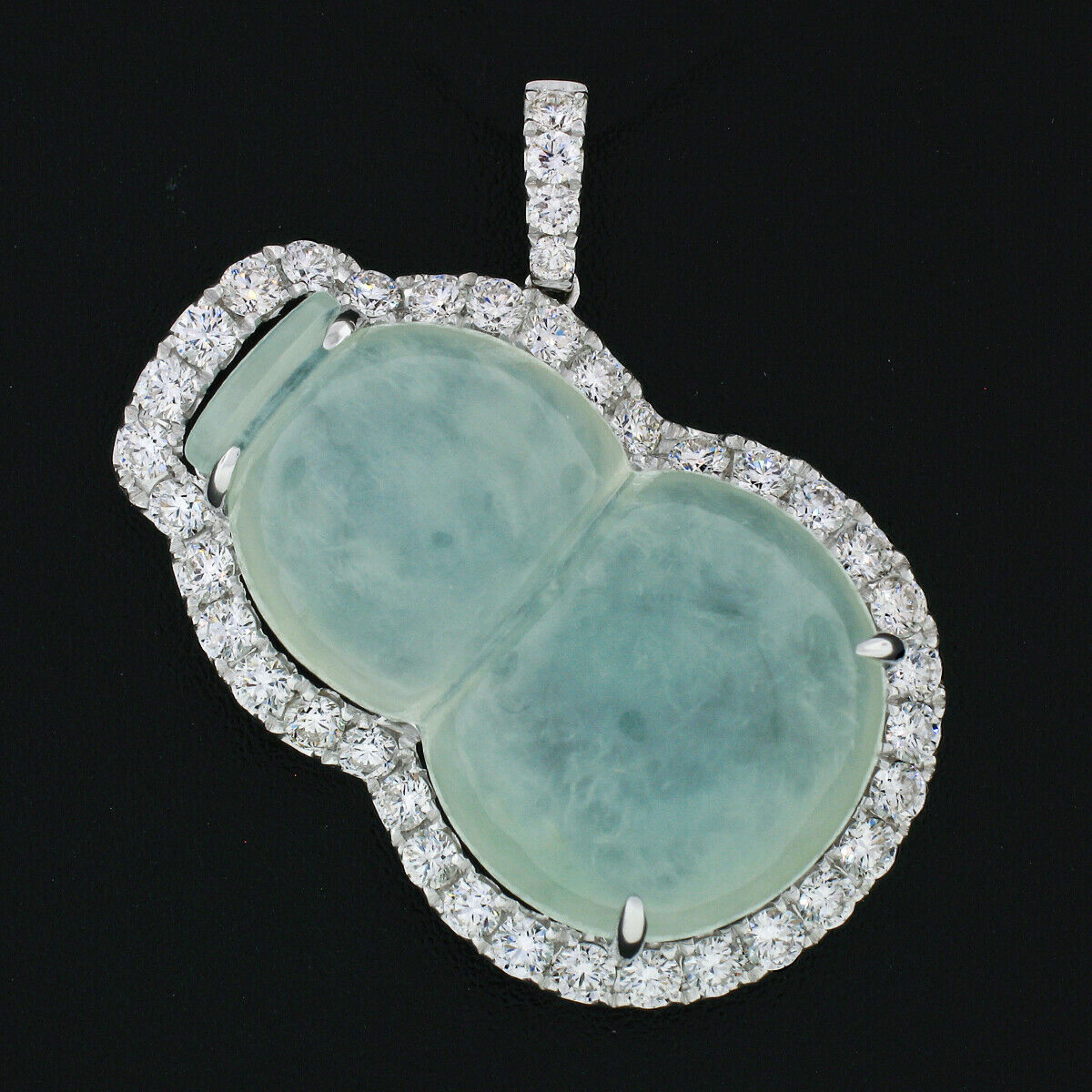 Here we have a beautiful jadeite and diamond pendant crafted from solid 18k white gold. The pendant features a free-form carved, natural, pale grayish green jadeite jade prong set at its center. The jadeite is surrounded by a halo of super fine