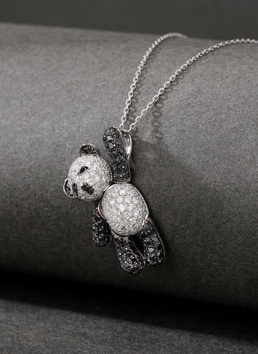 Total Weight: 25.00 g
Net Gold Weight: 4.932 g
Main Stones: 10 Black Diamonds, 0.050 CT
Secondary Stones: 193 Diamonds, 1.540 CT

This adorable necklace features a charming bear design crafted in 18K white gold, adorned with black and white