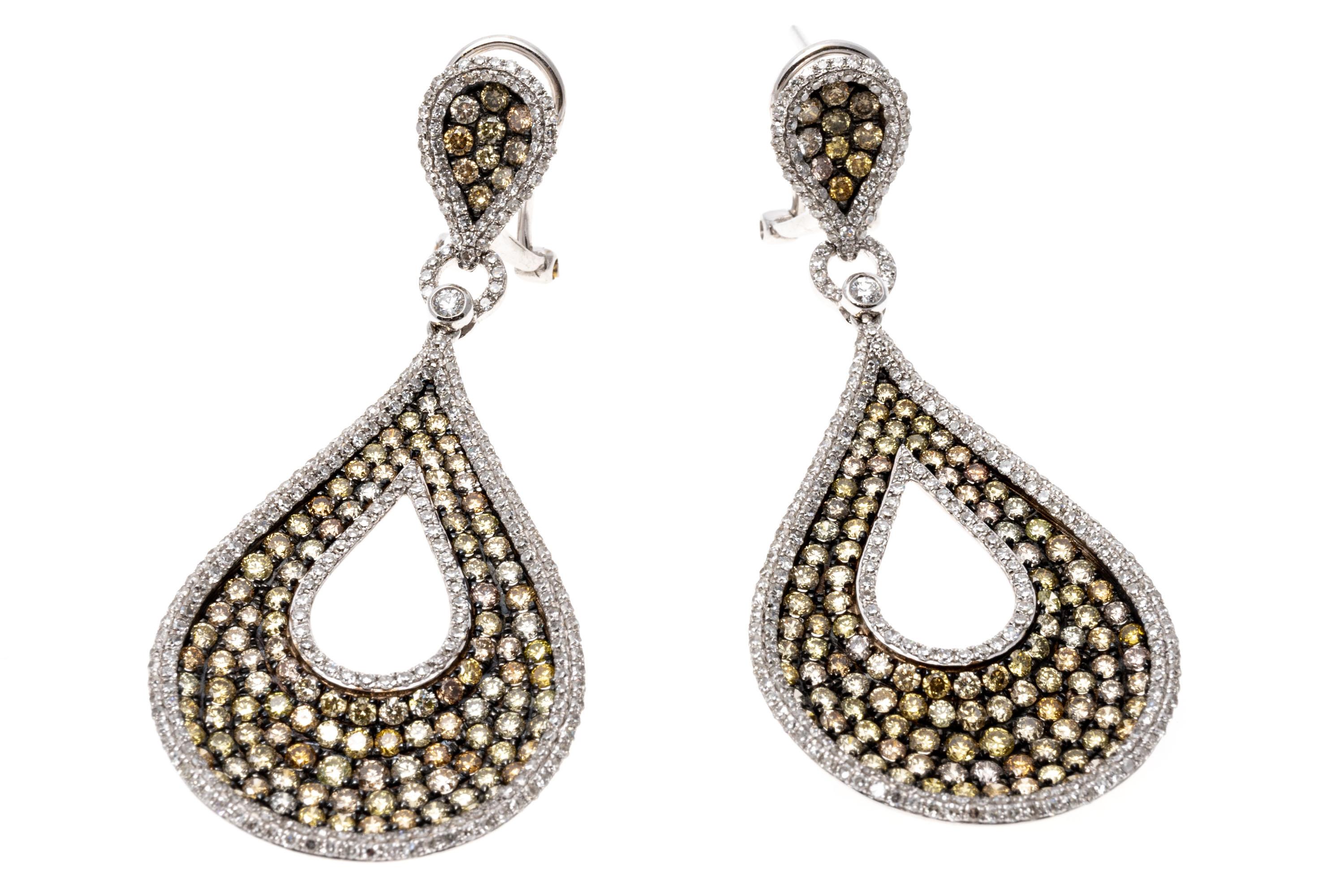 Mark a truly spectacular statement with these pendant earrings. The pendants suspended from these earrings have a teardrop shape with a cutout at the center. Set into the pendant are brilliant cut colored diamonds ranging from a soft yellow to pale