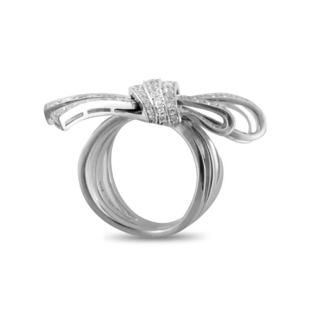 Astonishing harmony, captivating artistic shapes and exquisitely splendid craftsmanship meet in this remarkable ring. Edgy, cool and with a drizzle of diamonds this asymmetric modeled tied bow is placed at the center of a gold band made in 18K white