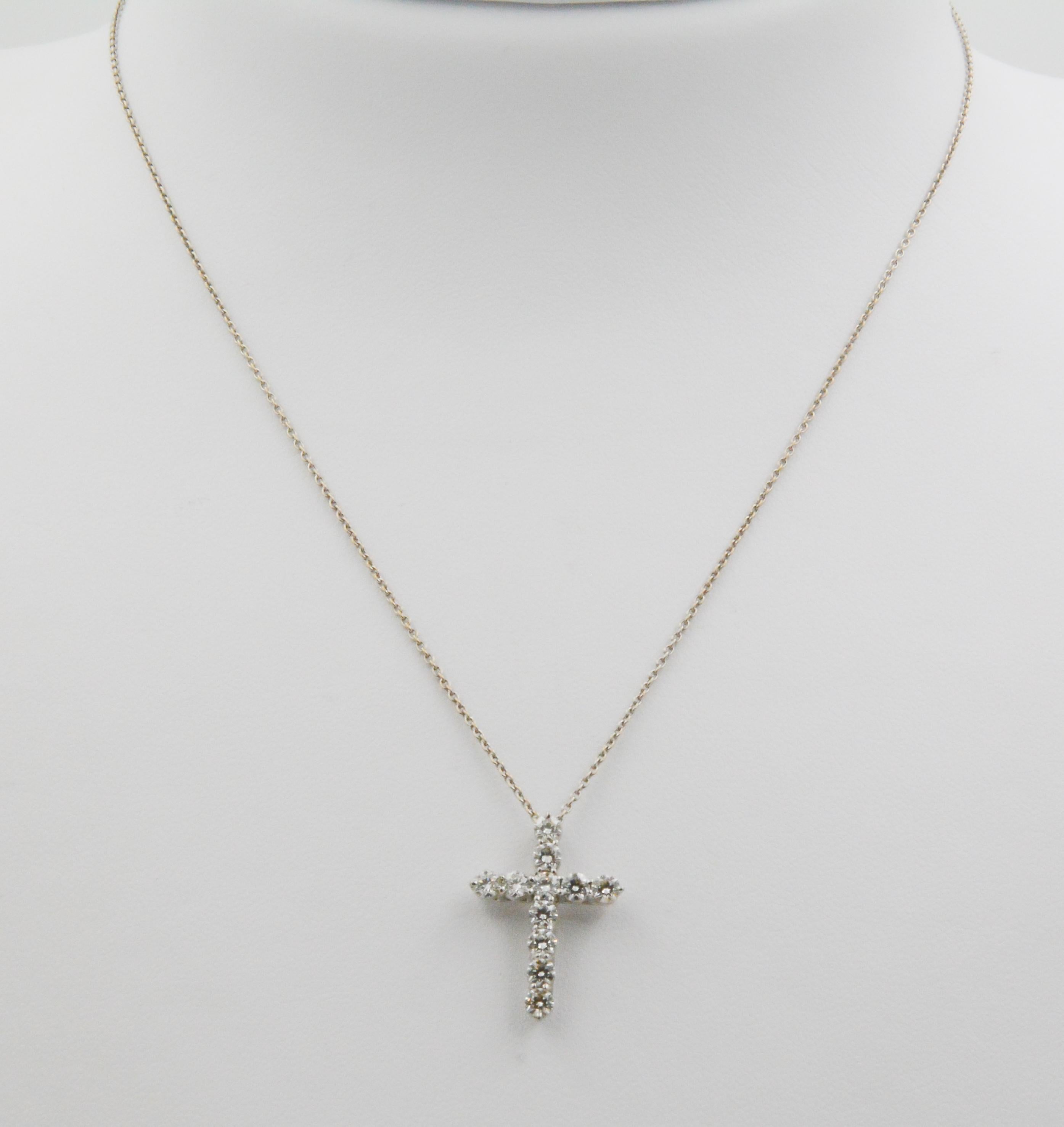 In the shape of a cross, this 18k white gold and diamond pendant features 11 round brilliant cut diamonds with F-G coloring and VS clarity, weighing a total 1.00 carats. The diamonds are set in a shared prongs on a 16” fine chain with a lobster claw