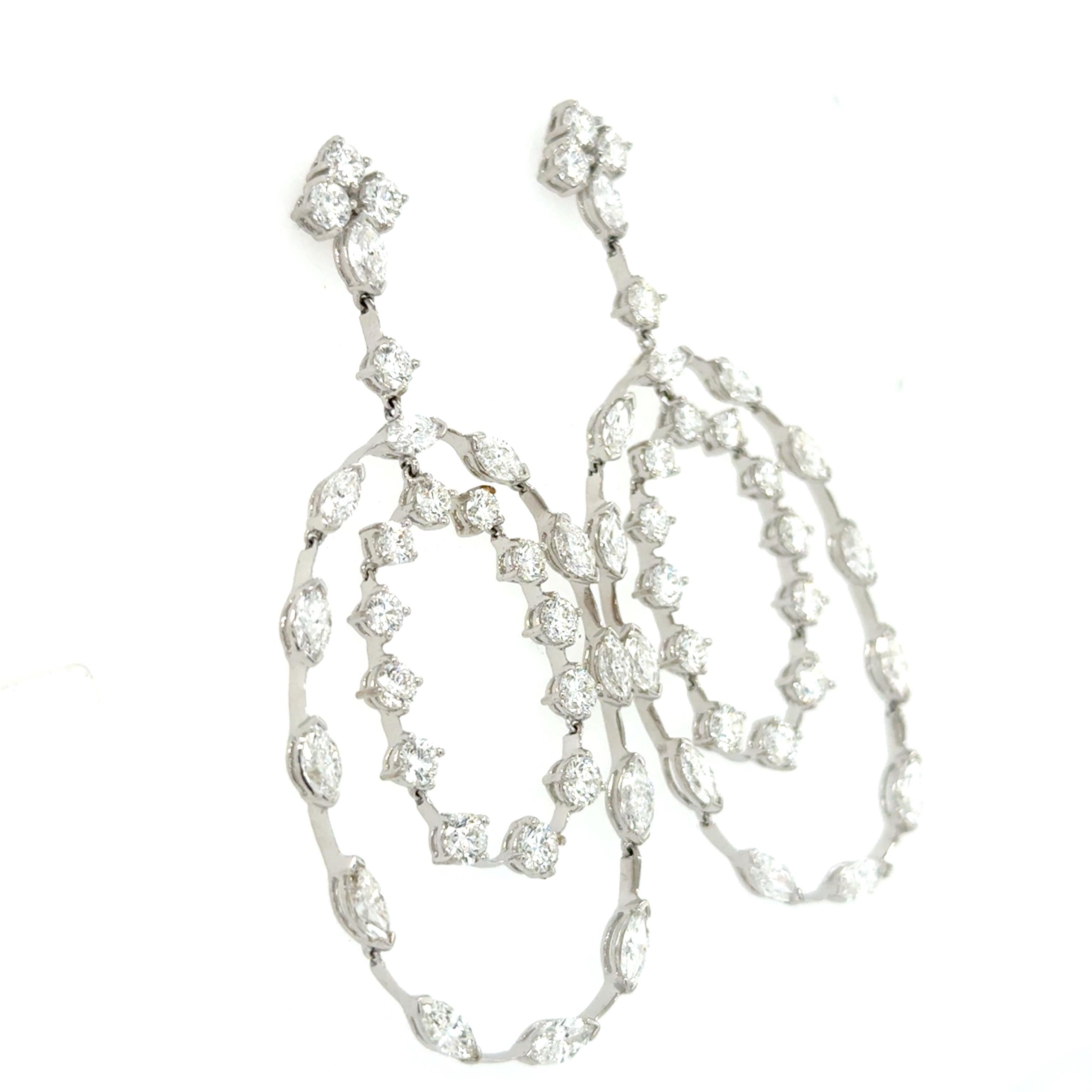 Questi bellissimi orecchini scintillanti sono composti da un grappolo di diamanti sull'orecchio che sospende un anello esterno di diamanti taglio marquise e un anello interno di diamanti taglio brillante, per un totale di 15,55 carati. Questi