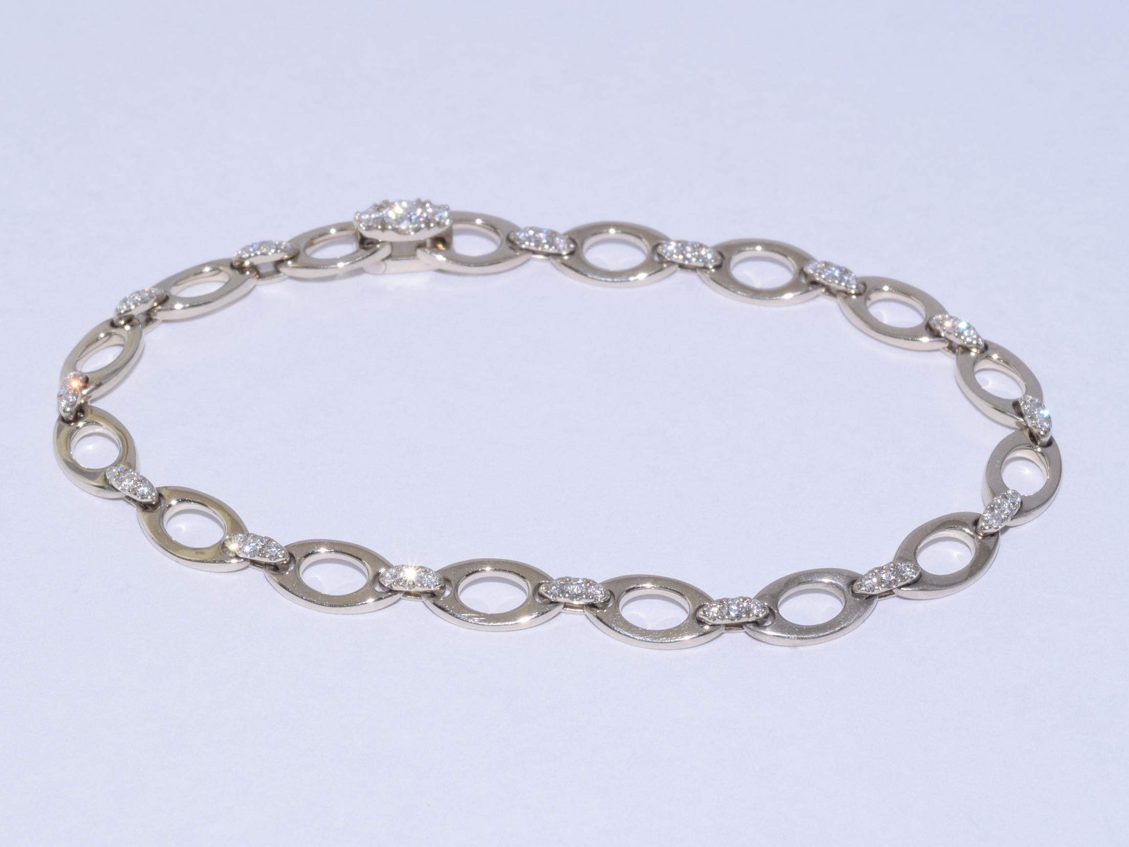 Navette shaped links formed in 18 karat white gold are joined with diamond set bar links accented with 48 round diamonds totaling approximately 0.55 carats. The bracelet measures 6.5 inches in length and 1/4 of an inch wide. This style can be worn